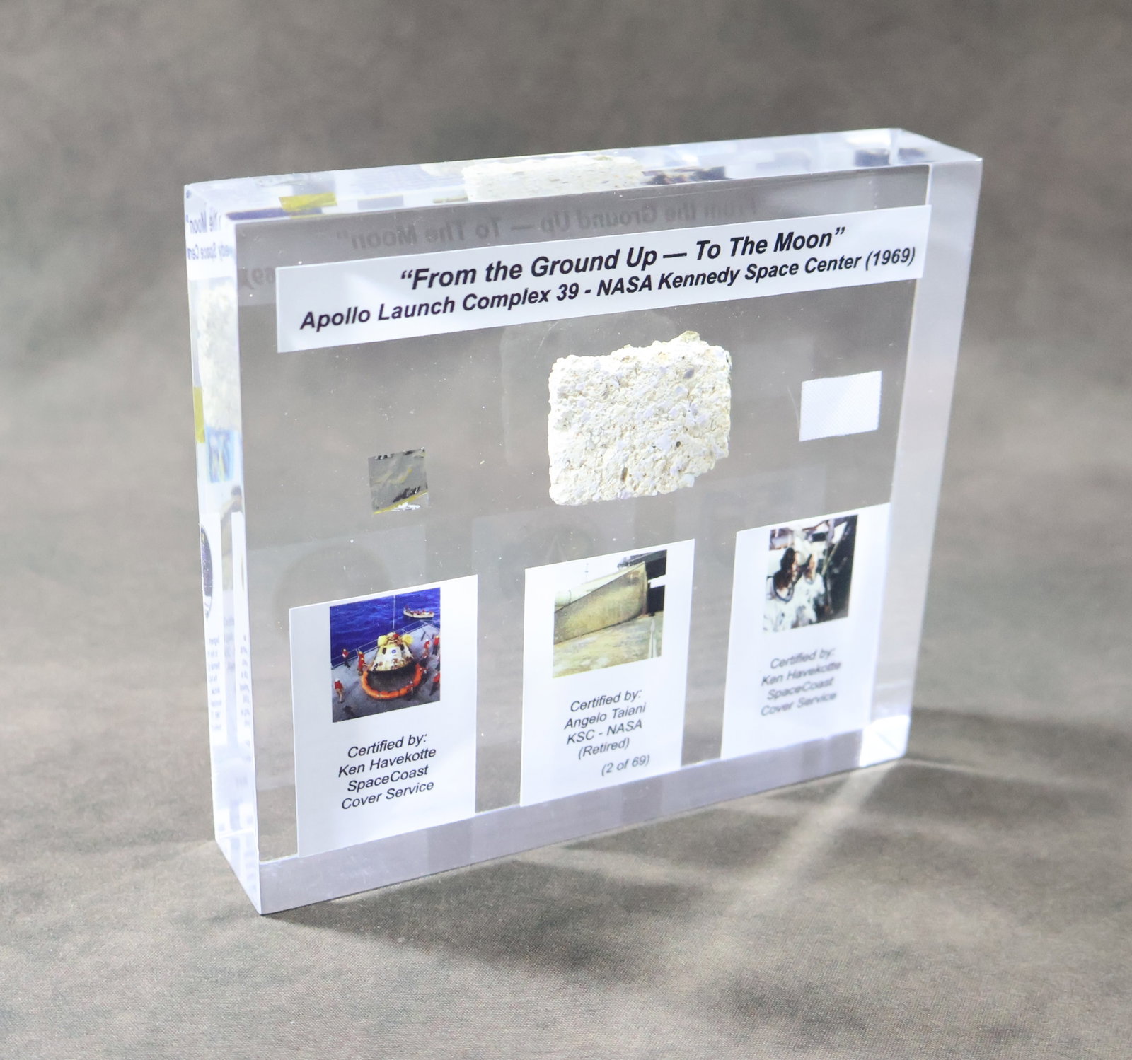 Apollo Era Flown Fragments Lucite Display: This is an especially nice Lucite display. This 5" x 5" x 1" Lucite displays three sections of fragments retrieved during the Apollo program. These include a 0.5" section of Beta Cloth Patch that was 