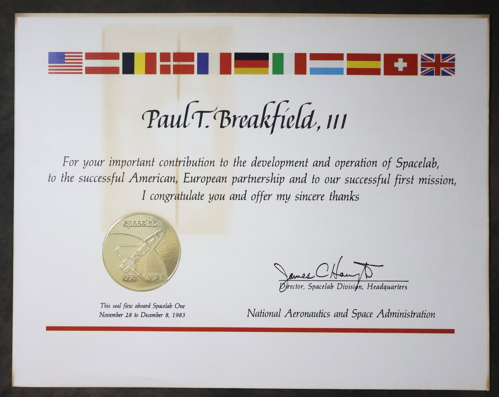 Flown STS-9 Spacelab Seal Presentation: A NASA appreciation award presentation awarded to Paul Thomas Breakfield III, who was a Deputy Director of Shuttle Engineering and Director of Payload Flight Operations. He retired in 1999 as