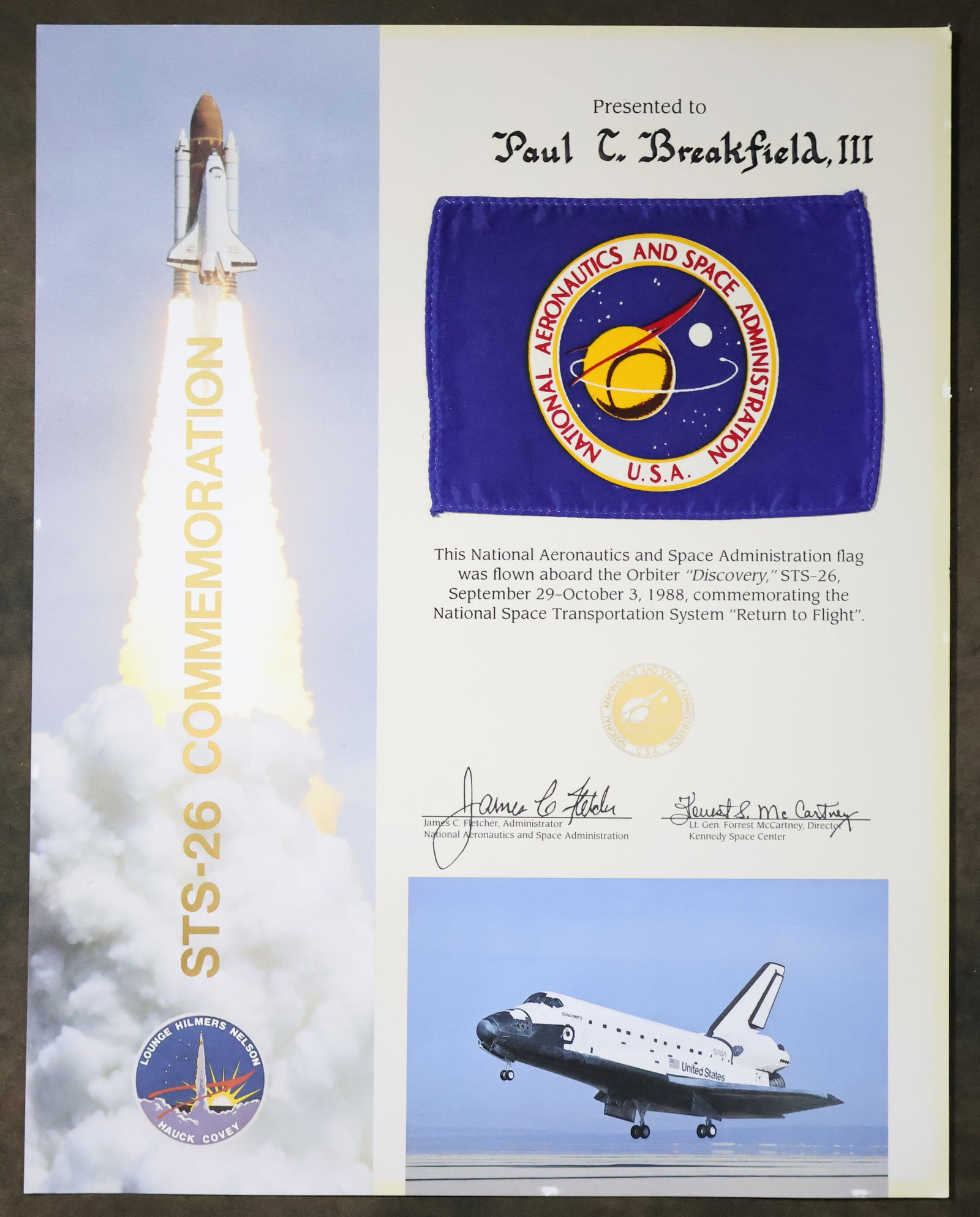 Flown NASA Flag STS-26 Award: A NASA STS-26 commemorative award presentation that displays a 4" x 5.5" NASA Flag that was flown aboard the Orbiter "Discovery" during the STS-26 mission. This is a commemorative award for the "Retur