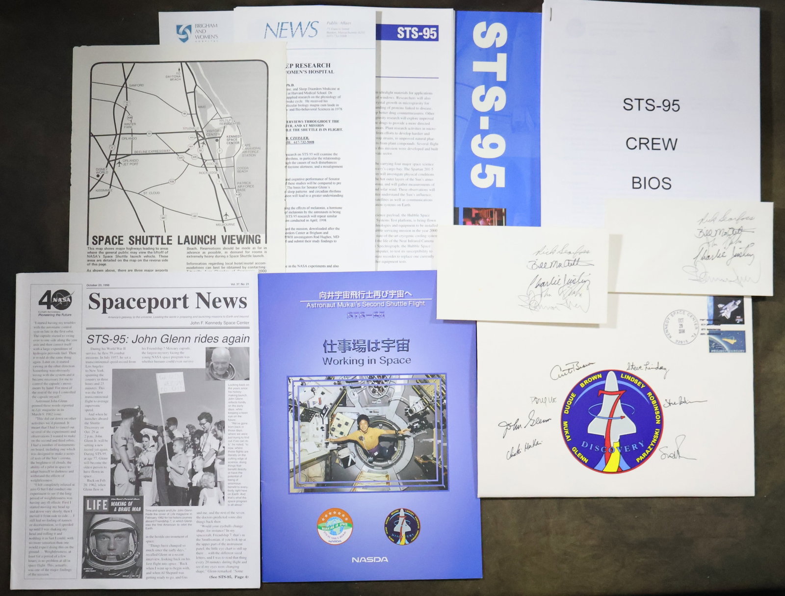 STS-95 Crew Signed Cover & Launch Day Press Kit: An STS-95 large 8" x 11" mission cover that displays the cancellation stamp dated October 29, 1998 for the launch day of the mission. The also displays the mission emblem with the hand signed names