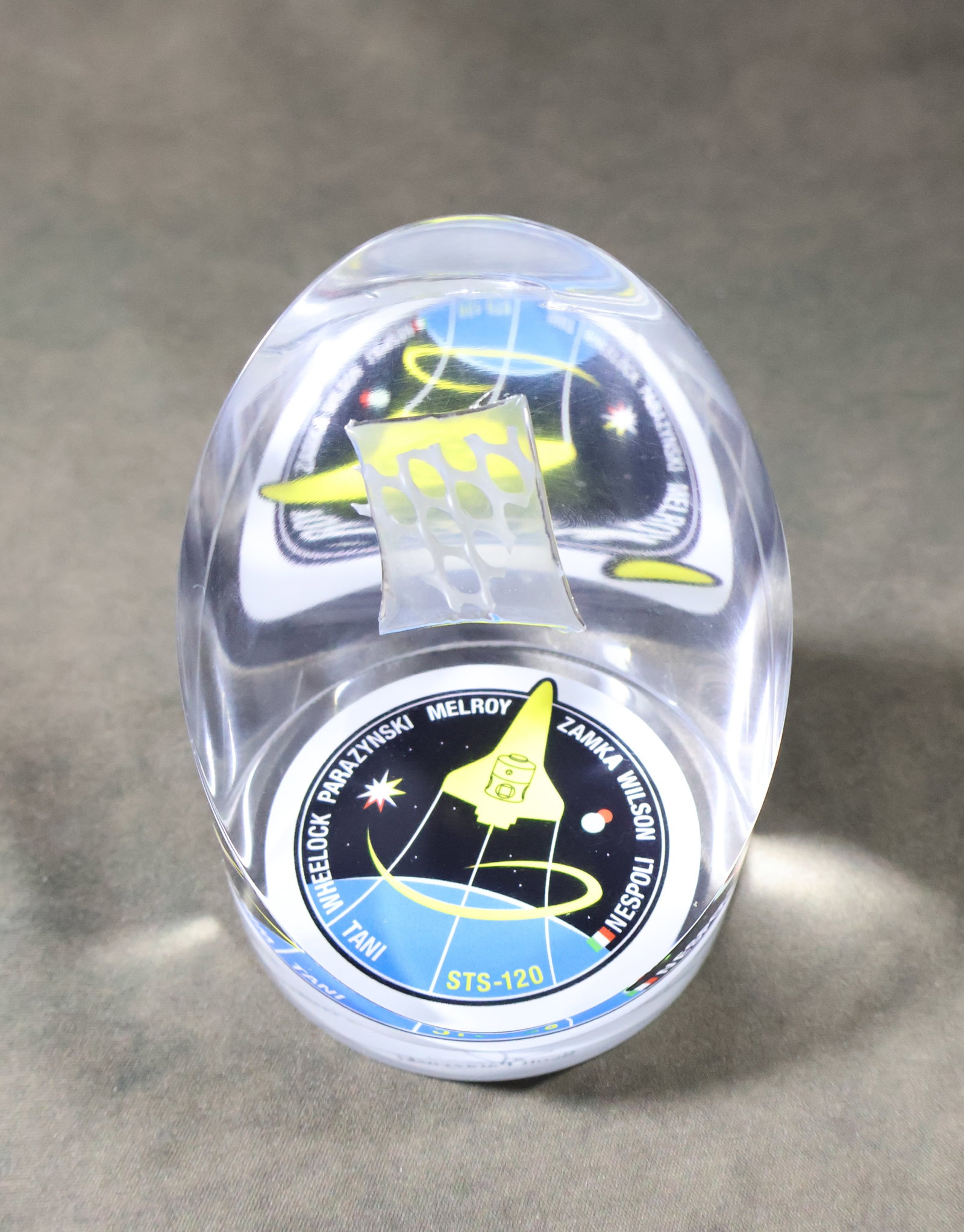 Flown STS-120 Disposable In-Suit Drink Bag Section Lucite: Flown section of Disposable In-Suit Drink Bag capsulated in a STS-120 Lucite display. This 3.25" x 2.75" Lucite displays a 0.75" x 1" section of Disposable In-Suit Drink Bag flew in space during the S
