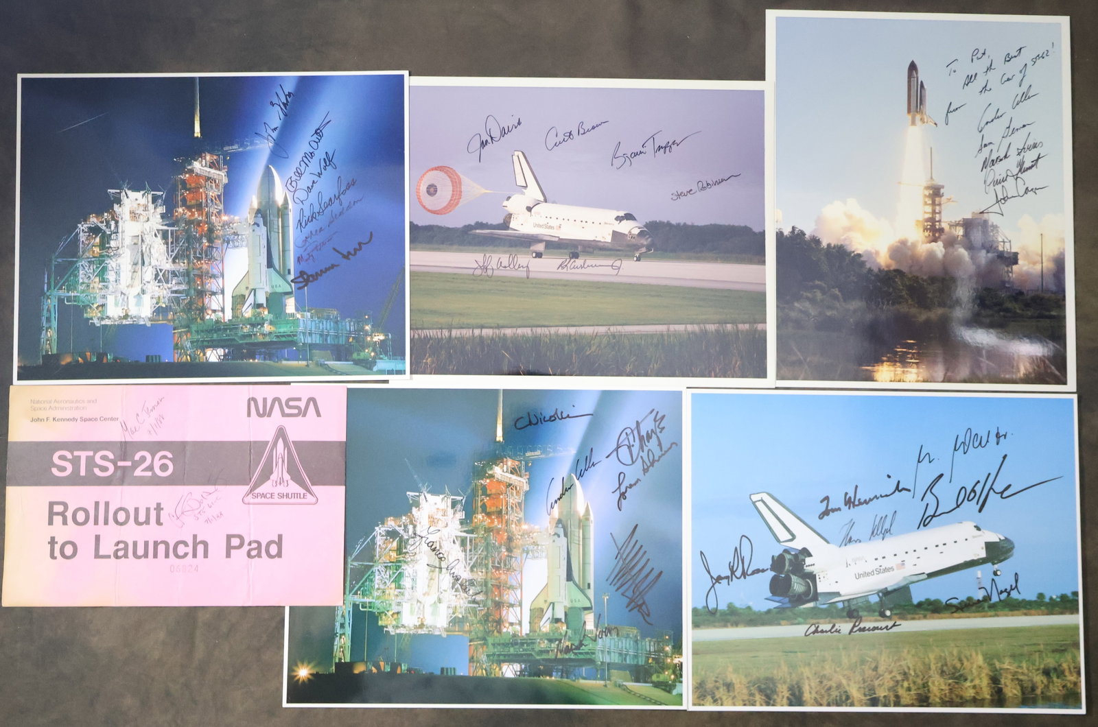6 - Multi Shuttle Astronaut Signed Items: A nice collection of three NASA lithographs, two original NASA photographs showing images of launches, Shuttles on the Launch Pad and landings. Also a STS-26 Rollout to Launch Pad pass. All the items 