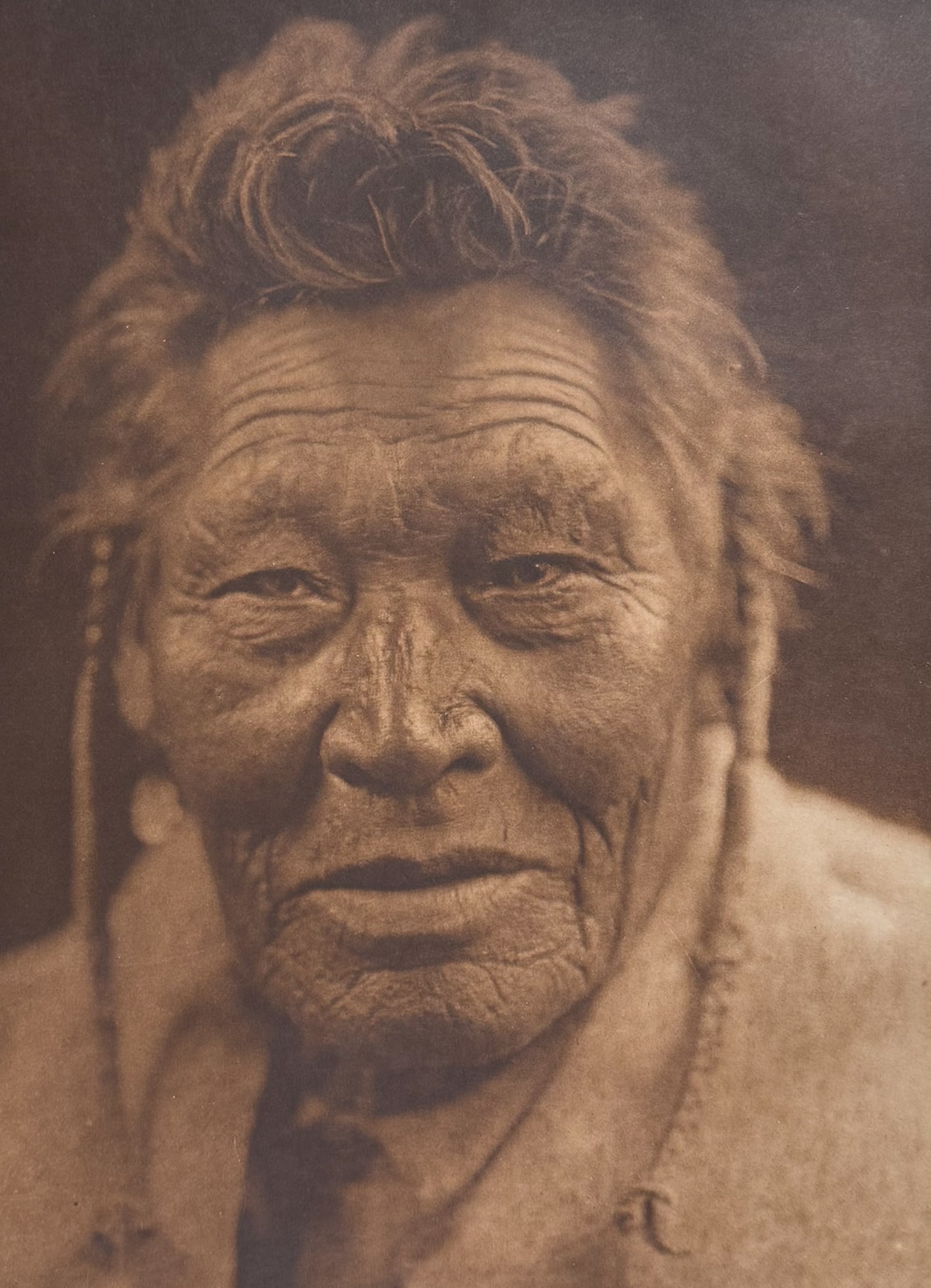 Edward Curtis, Folio - Tsaassi-Mis-Salla ("Crow with Necklace") - Sarsi: Curtis's description of the image: The name, colloquially rendered as Crow Collar, refers to a neck- ornament of crow-feathers. Description of the work: This moving photogravure in folio size is from 