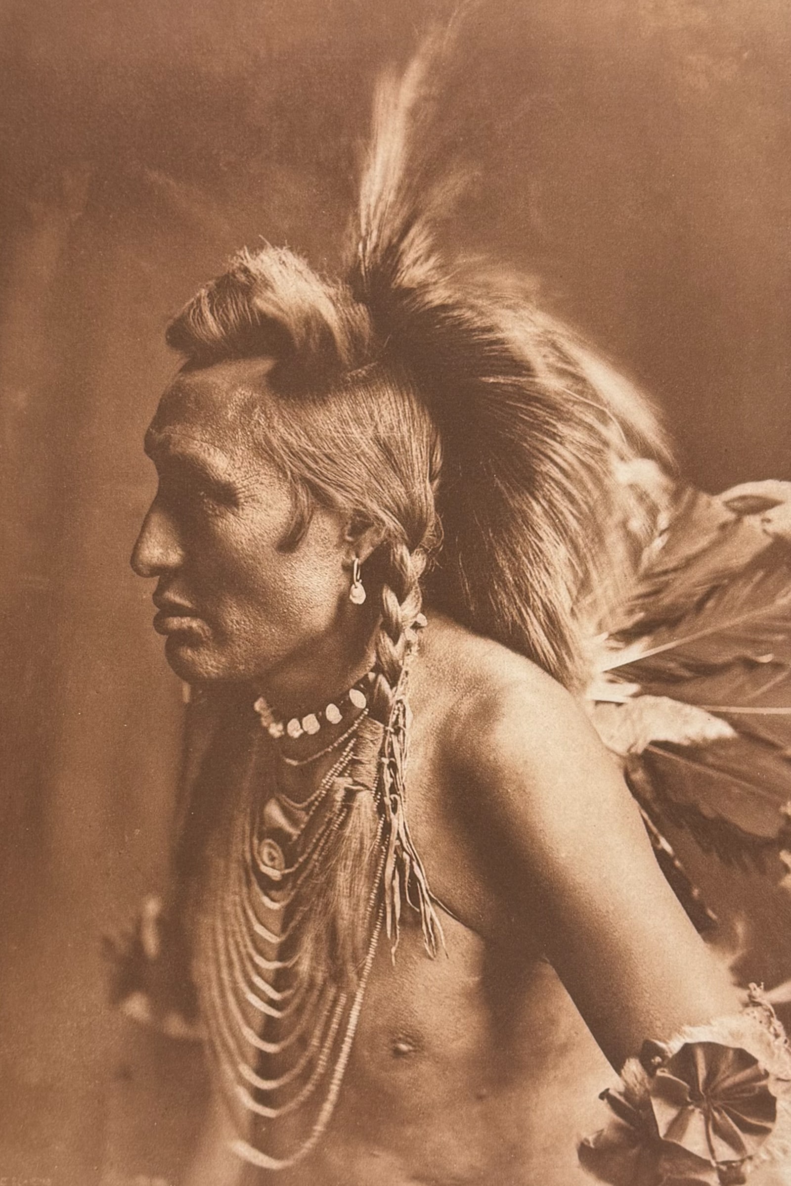 Edward Curtis, Folio - Gambler - Piegan: This moving photogravure in folio size is from Edward Curtis's The North American Indian being a Series of Volumes Picturing and Describing the Indians of the United States and Alaska. Edited by