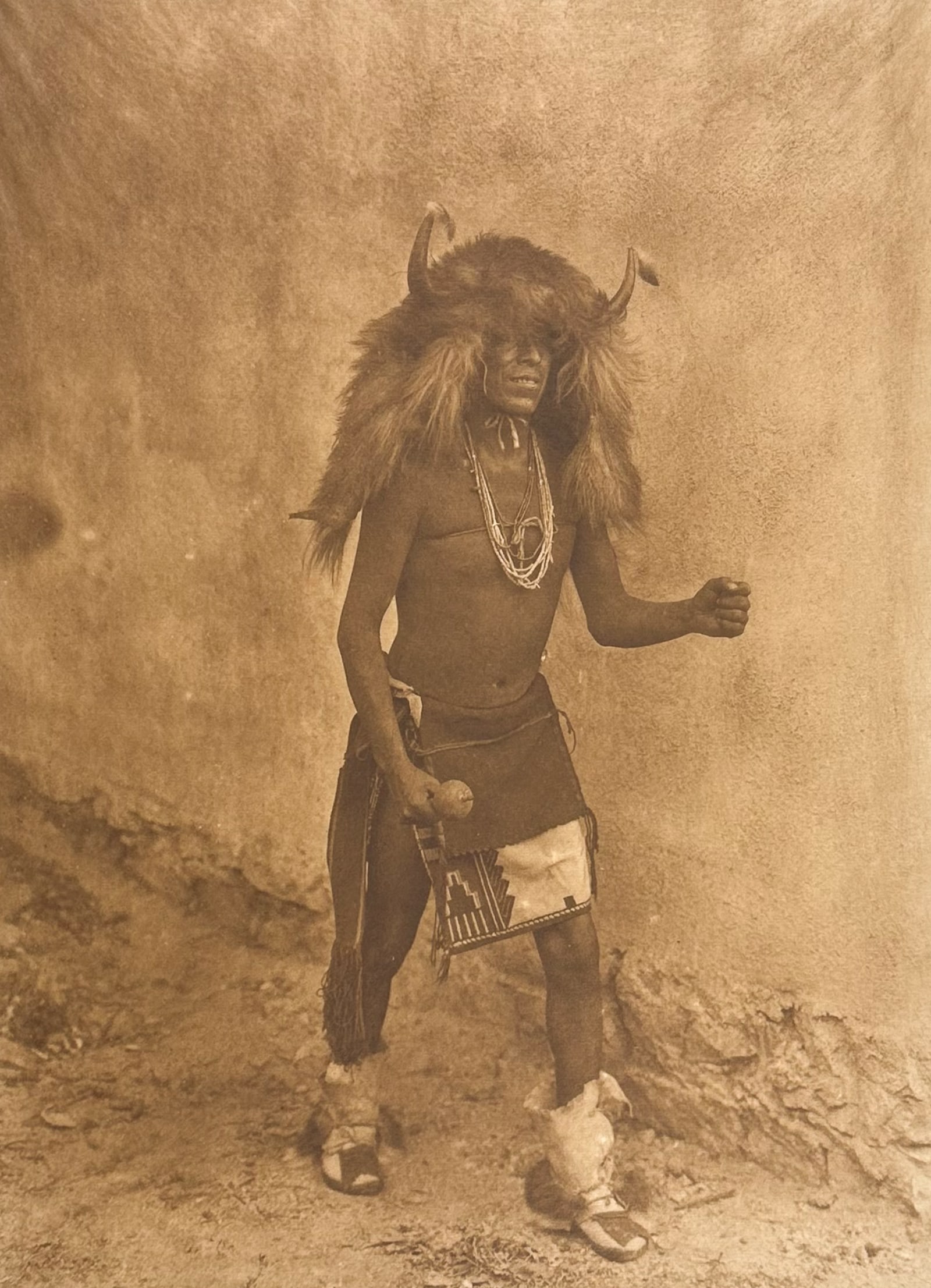 E Curtis, Folio, Japanese Tissue - Sia Buffalo Dancer: Description of the image: The Buffalo dance of the Keres is almost exactly the same as that of the Tewa. The performers are two young men with head-dresses of buffalo-hair and horns, and a girl wearin