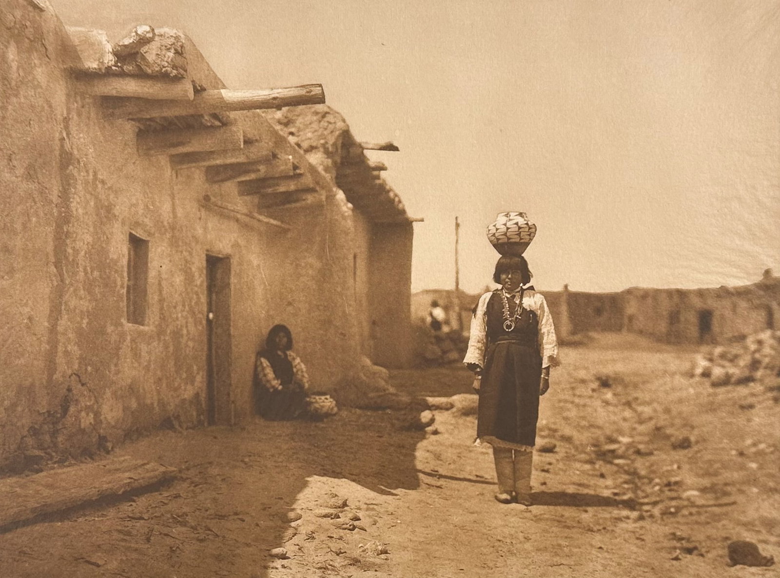 Edward Curtis, Folio - Sia Street Scene: Description of the image: Sia is situated on the north bank of Rio Jemez, a few miles below Jemez pueblo. Ancient Sia, having participated in the revolt of 1680, was completely destroyed and a large n