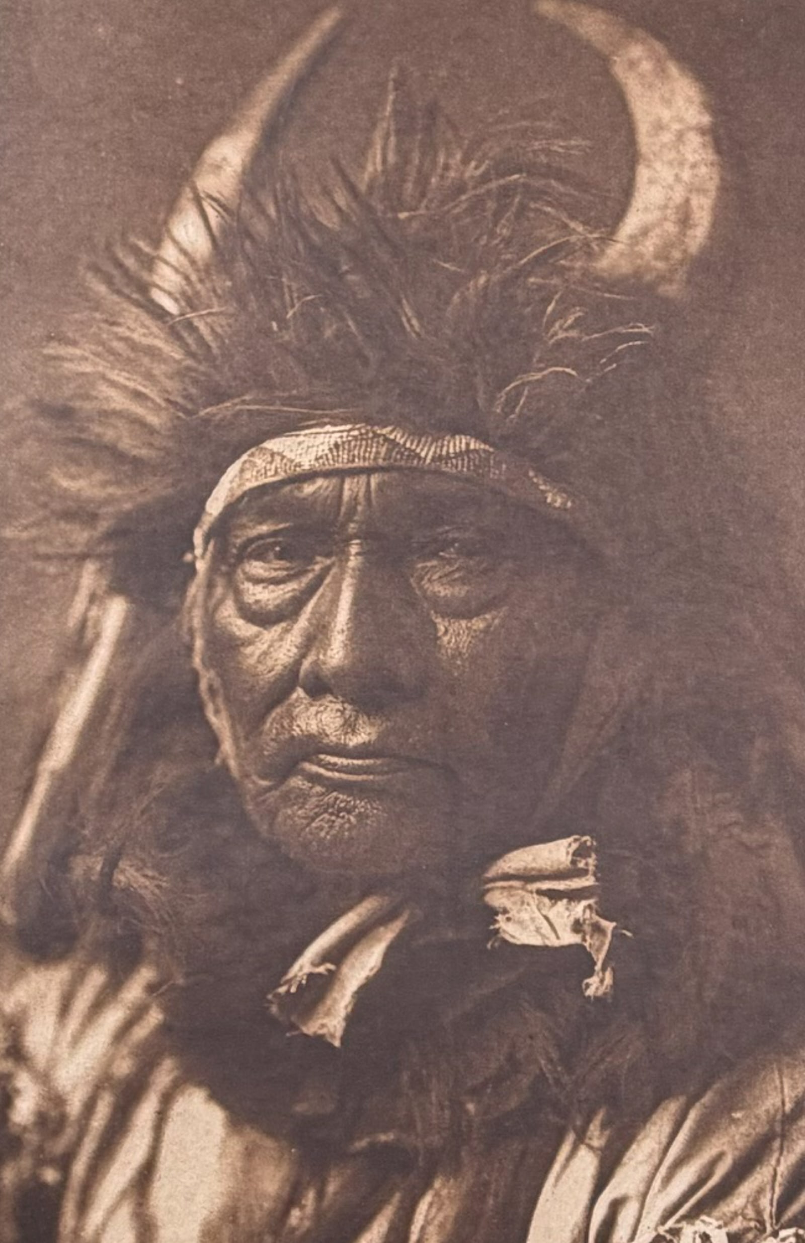 Edward Curtis, Folio - Bull Chief - Apsaroke: This moving photogravure in folio size is from Edward Curtis's The North American Indian being a Series of Volumes Picturing and Describing the Indians of the United States and Alaska. Edited by