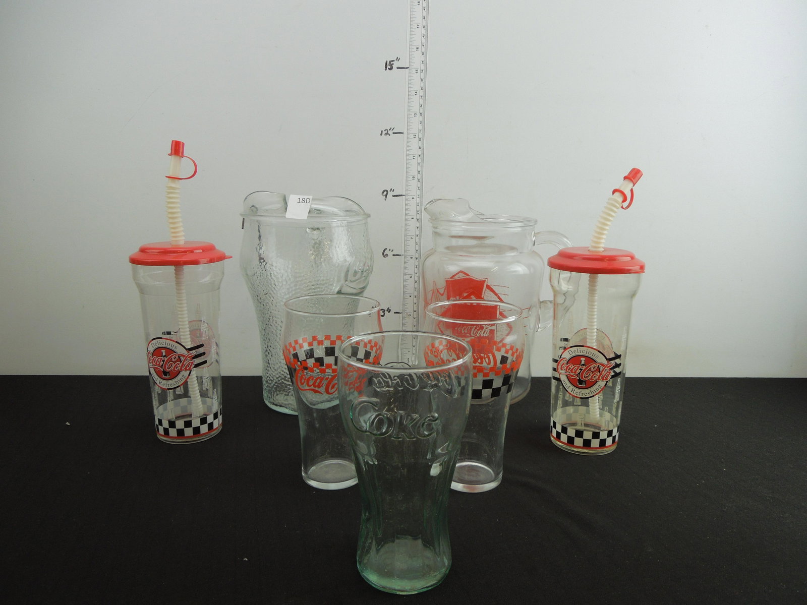 Two Coca-Cola Glass Pitchers, Two Plastic Cups, and: Two Coca-Cola Glass Pitchers, Two Plastic Cups, and Three Drinking Glasses all from Coca-Cola