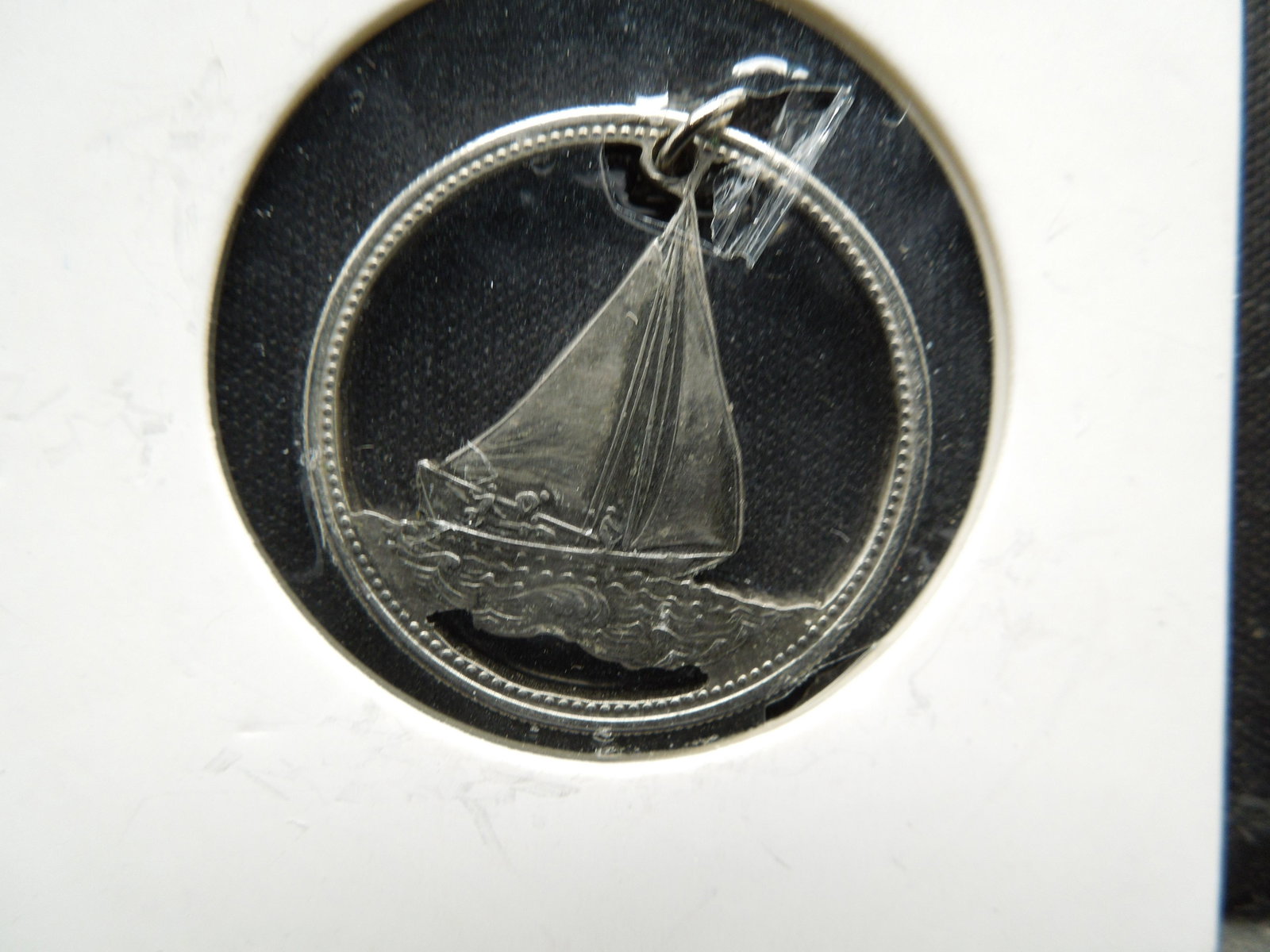Canadian quarter that has had been cut out leaving the: Canadian quarter that has had been cut out leaving the sail boat