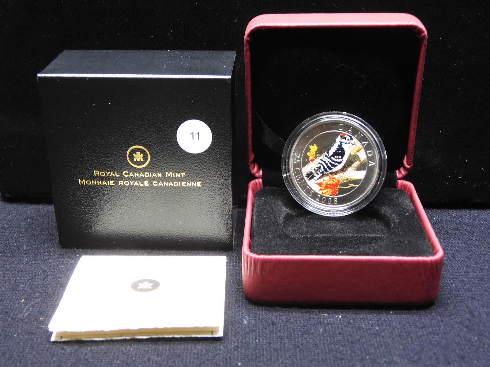 2011 Canada nickel plated steel 25 Cents. This colored: 2011 Canada nickel plated steel 25 Cents. This colored coin features The Downy Woodpecker. Specimen quality in original box with COA. Mintage: 25,000.