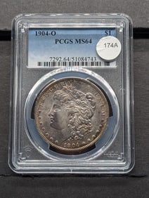 1904-O Morgan Dollar. Slabbed by PCGS, top grader, as MS64. Attractive golden toning on obverse.