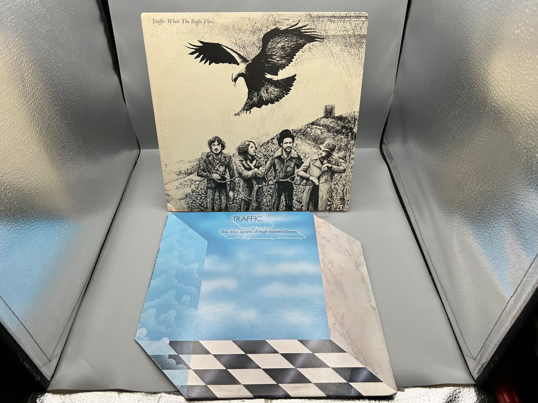 Traffic (2 LP Lot): When the Eagle Flies (1974); and The Low Spark of High Heeled Boys (1984),: Traffic (2 LP Lot): When the Eagle Flies (1974); and The Low Spark of High Heeled Boys (1984), reissue, cover is diagonally die-cut - Records have not been tested by the auction house for play quality