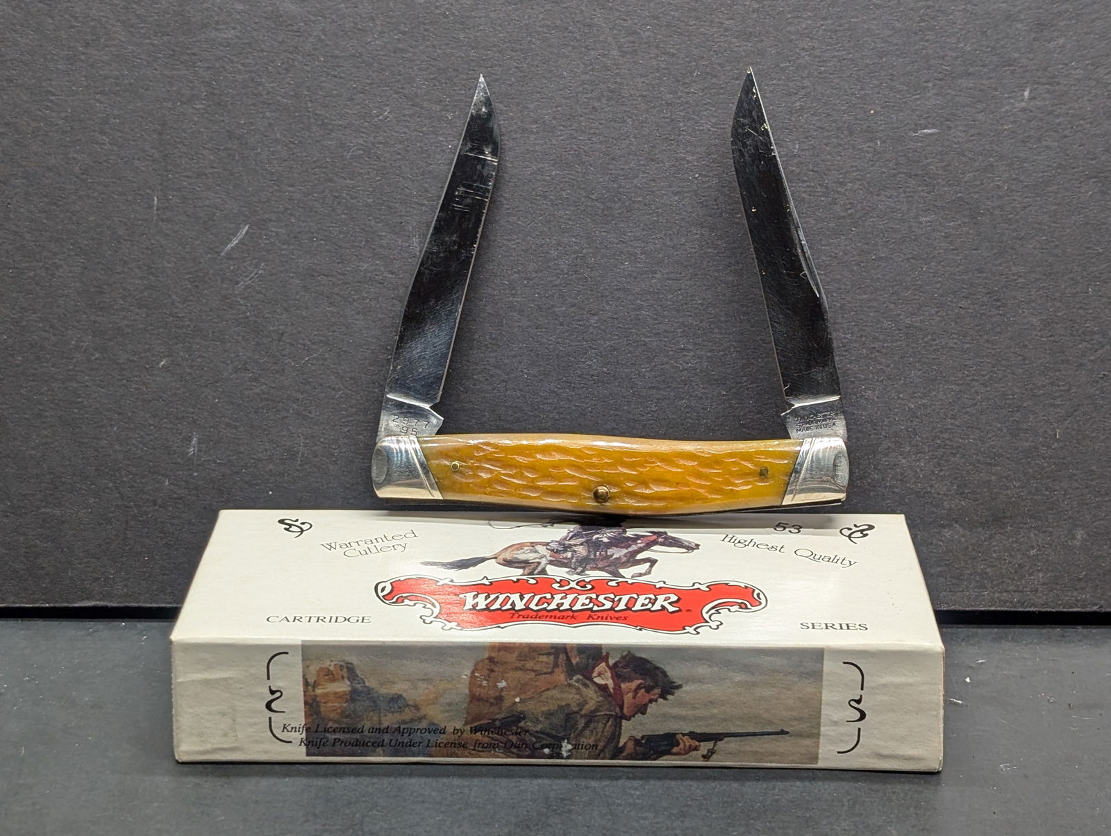 1995 Winchester USA 115 2977 Yellow Bone 30-30 Shield 995 2 blade 4" 30 30 CARTRIDGE SERIES Knife: Winchester 2977 '95, Cartridge Series Special Edition, 2.5" blade, textured yellow bone handle, good condition with some blade wear, includes original box.