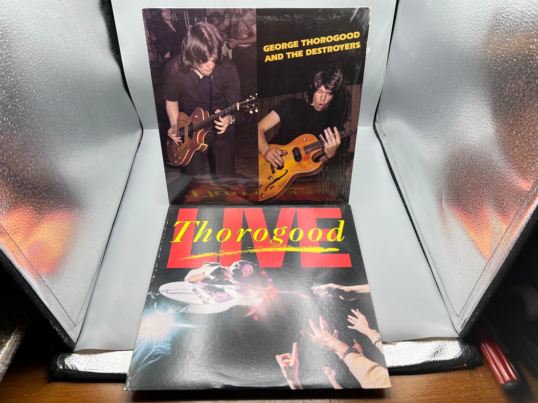George Thorogood & The Destroyers (2 LP Lot): Self-titled (1977), in original shrinkwrap; and: George Thorogood & The Destroyers (2 LP Lot): Self-titled (1977), in original shrinkwrap; and Thorogood Live (1986) - Records have not been tested by the auction house for play quality. All items are