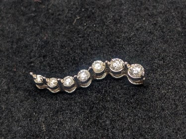 10K White Gold Pendant With 7 Graduated Size Diamonds. 0.8 grams.
