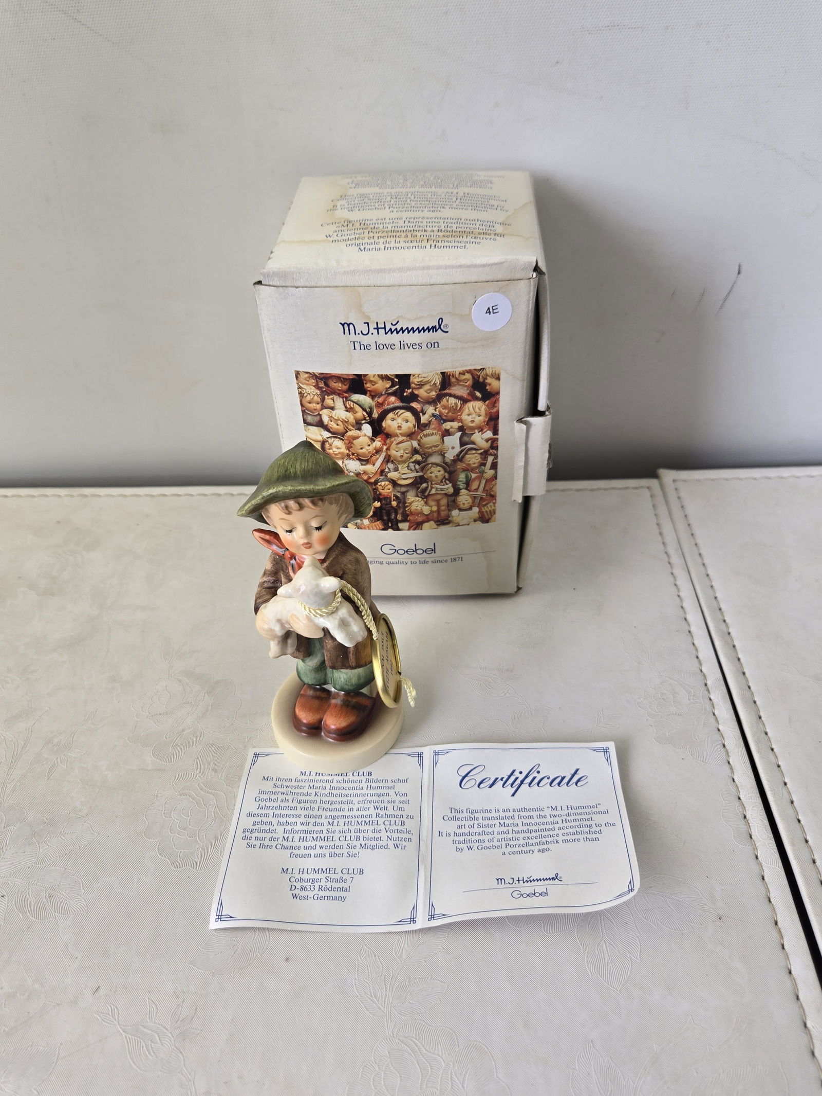 1992 Goebel M.I. Hummel Sch?ferbub Lost Sheep (HUM 383) Final Issue: This is an authentic, handcrafted, and handpainted M.I. Hummel porcelain figurine by Goebel, identified on its base as "Sch?ferbub Lost Sheep." The figurine depicts a young boy in a green hat and brow