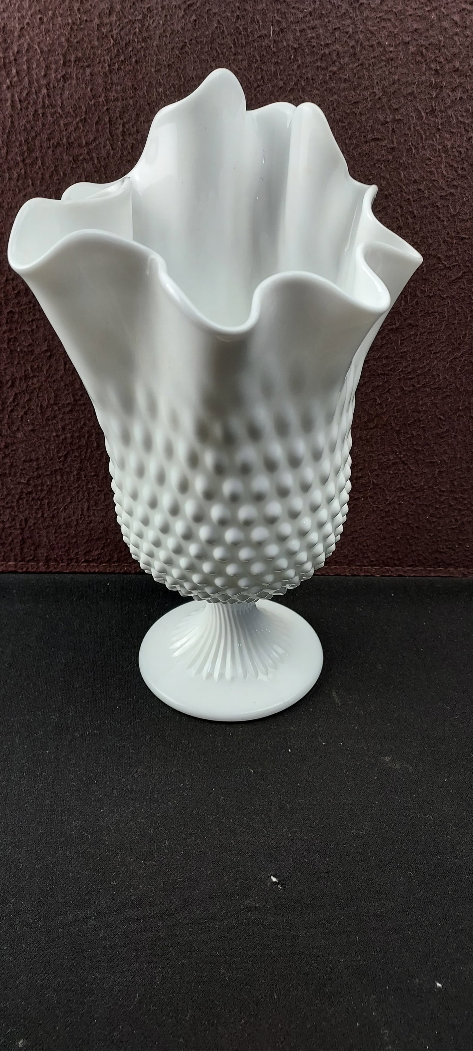 Fenton Milk Glass Hobnail #3755 Ruffled Rim Swung Vase: A vintage Fenton Milk Glass Hobnail #3755 Swung Vase. This elegant piece features a classic white milk glass construction with a distinctive hobnail texture covering its main body. The top edge is bea