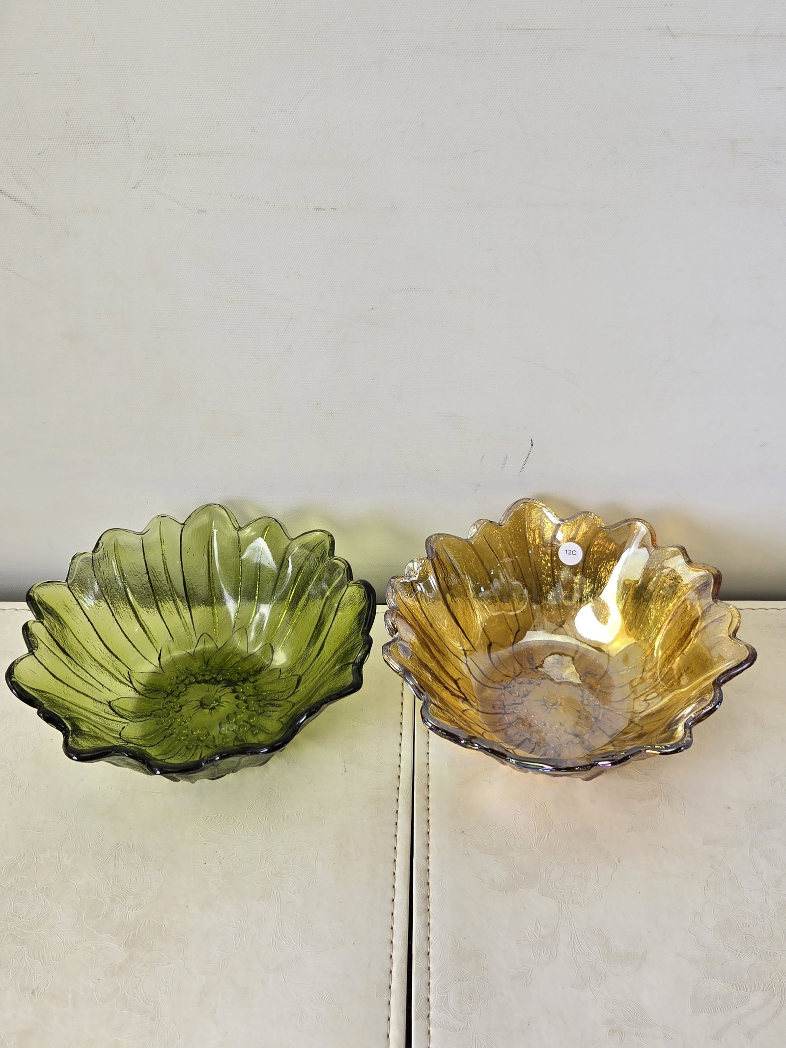 A Pair of Vintage Indiana Glass 'Sunflower' Bowls, one Marigold Carnival Glass and one Olive Green: This lot features a pair of vintage decorative glass bowls, both exhibiting a distinct floral or sunflower-like design. Each bowl features scalloped, petaled edges and a textured, raised pattern in th