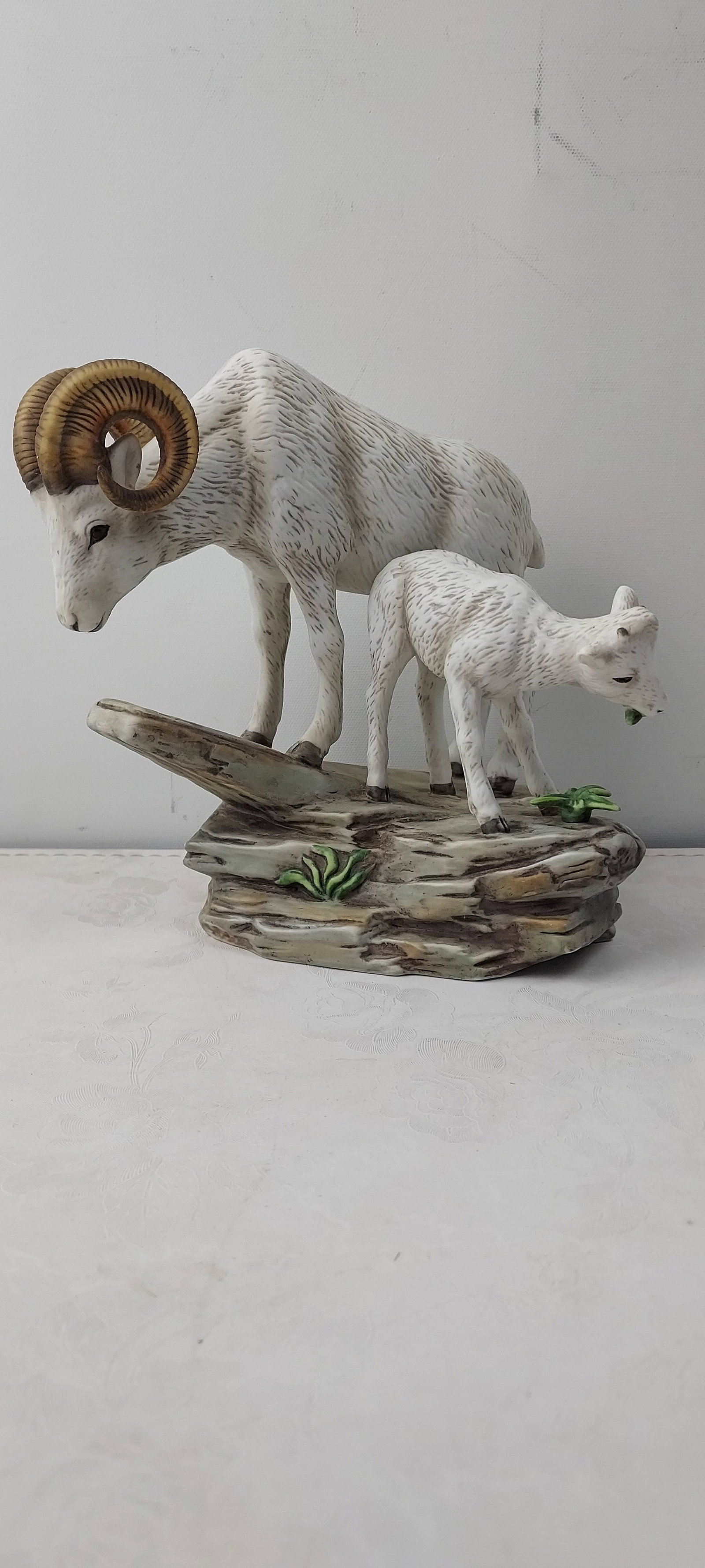 1984 HOMCO Masterpiece Porcelain Bighorn Ram and Lamb Figurine: This lot features a vintage 1984 HOMCO Masterpiece Porcelain figurine depicting an adult bighorn ram with prominent curled horns alongside a smaller lamb. The figures are rendered in white porcelain w