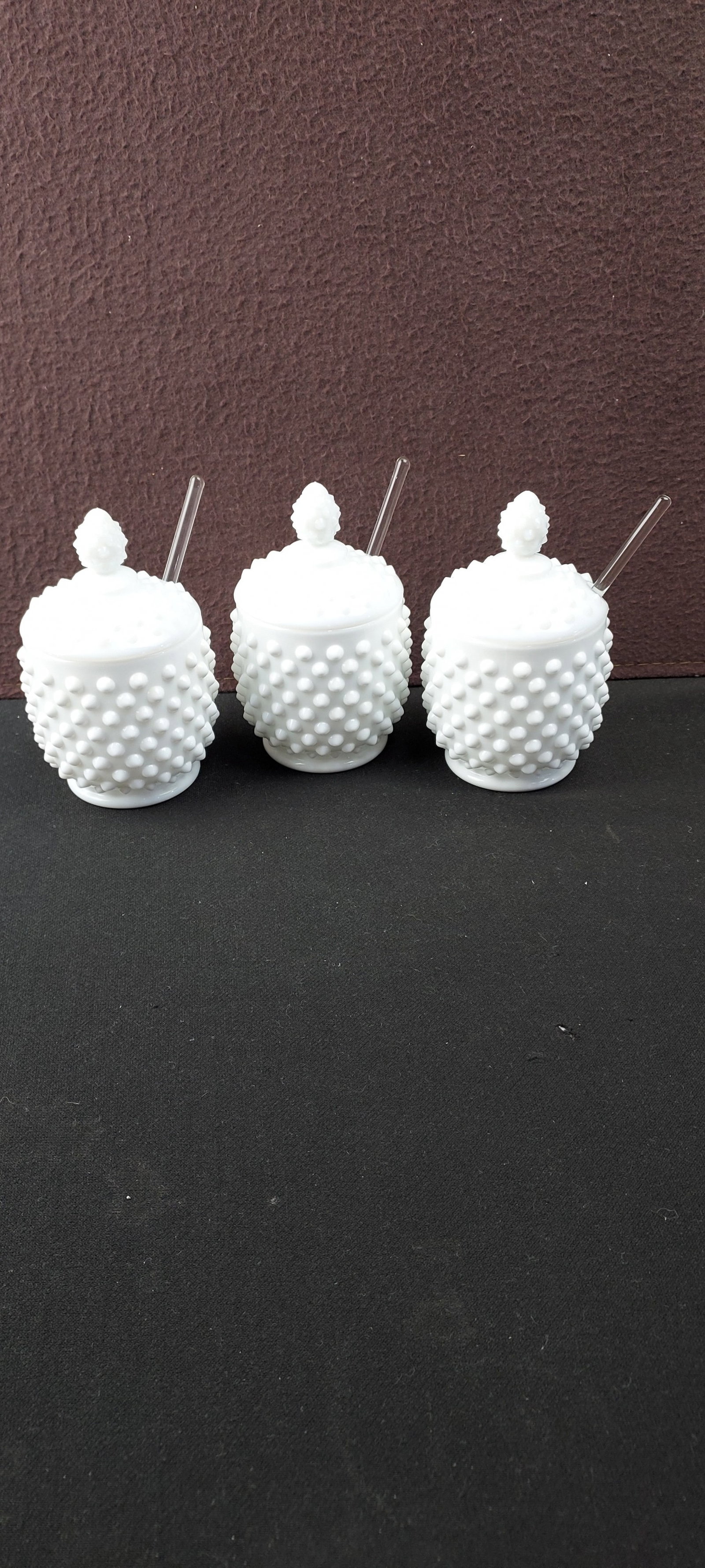 Set of Three 1953 Fenton Hobnail Milk Glass Jam/Jelly Bowls with Lids and Spoons: A Set of 3 1953 Fenton Hobnail Milk Glass Jam/Jelly Bowls with Lids and Spoons. Each bowl and its matching lid are crafted from white opalescent "milk glass" and feature a distinctive hobnail texture 