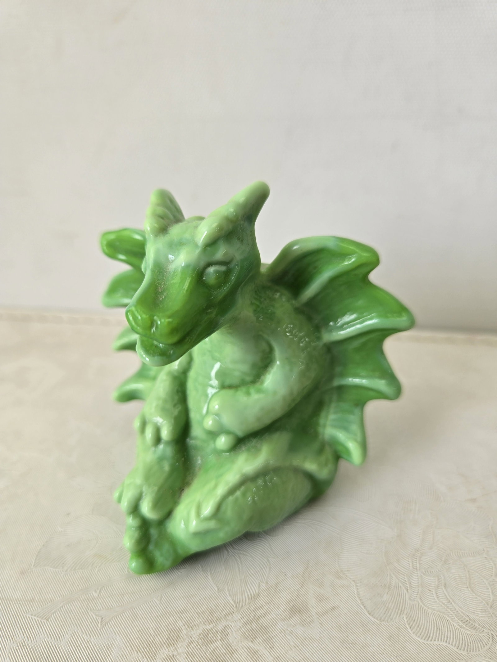 Fenton Art Glass Model 5386 'Chameleon Green' Dragon Figurine: This is a Fenton Art Glass Model 5386 'Chameleon Green' Dragon Figurine. The piece is crafted from translucent, light green glass with a glossy finish and exhibits a subtle opalescence, characteristic