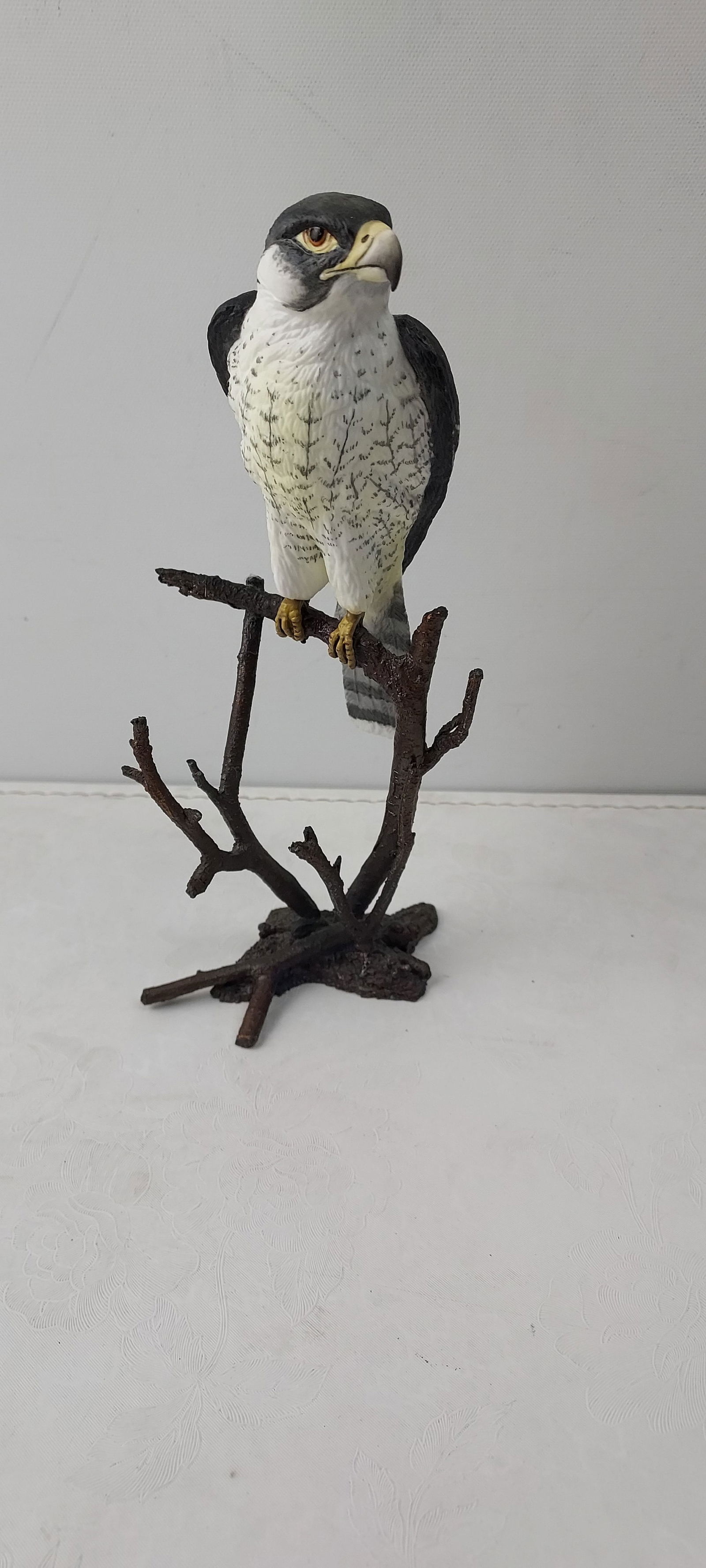 1985 Royal Worcester Birds of Prey Peregrine Falcon Figurine: A 1985 Royal Worcester hand-painted porcelain figurine depicting a Peregrine Falcon, part of the esteemed "Birds of Prey" series. The meticulously detailed falcon is perched upon a sculpted branch bas