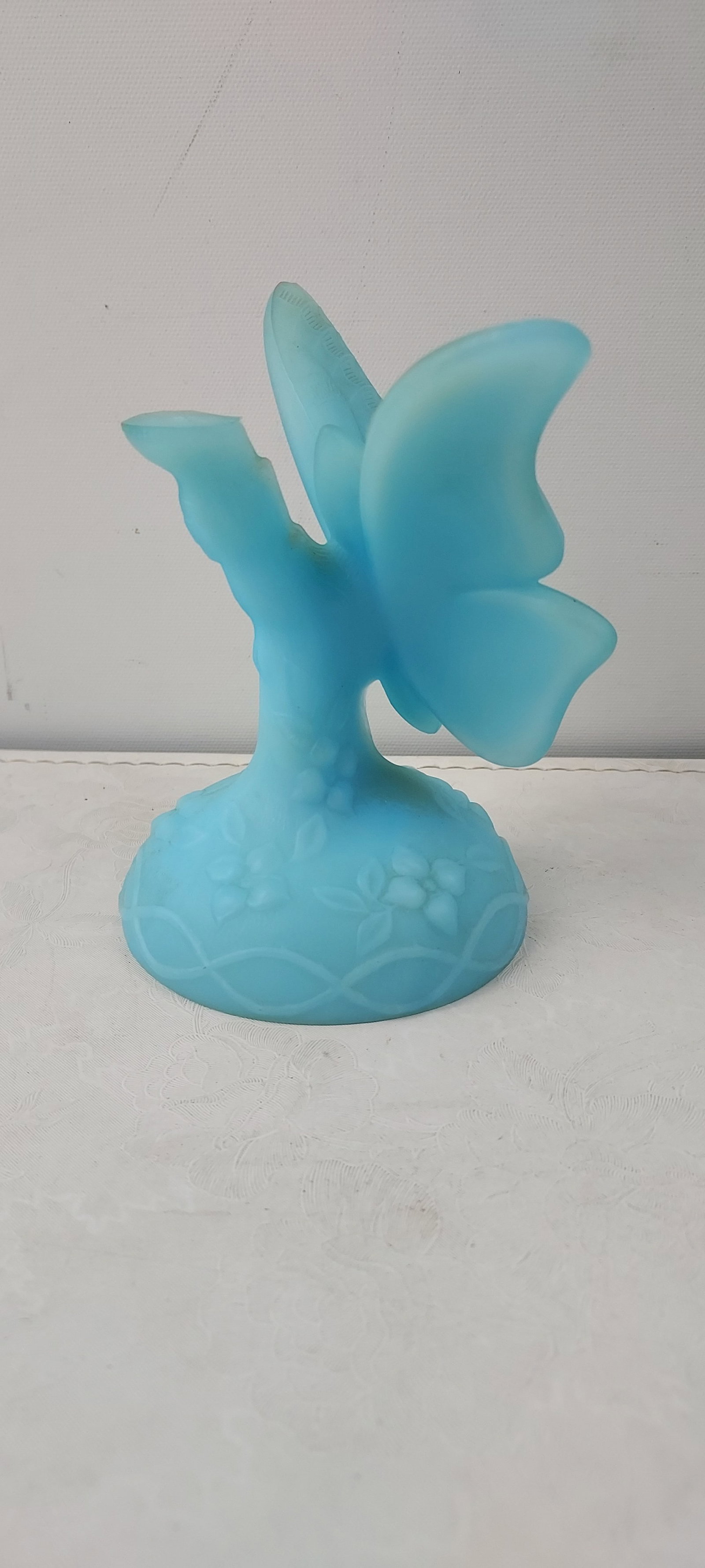 Fenton Blue Satin Glass Butterfly on Stand: This is an authentic Fenton Blue Satin Glass Butterfly. The piece is crafted from opaque, light blue glass, featuring a matte or "satin" finish consistent with milk glass. It is sculpted in the form o