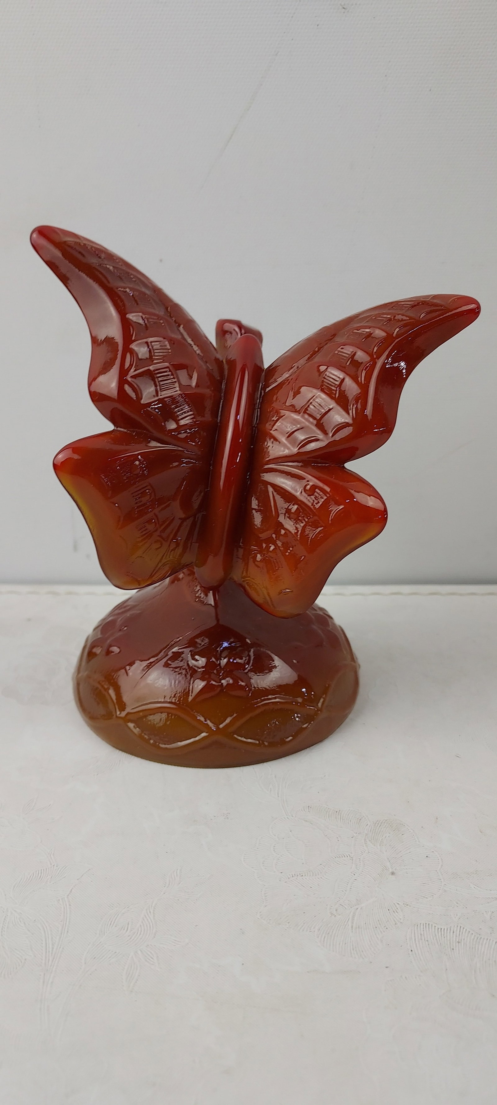 1989 Fenton Art Glass Mandarin Red Slag Glass Butterfly Figurine: A 1989 Fenton Art Glass Mandarin Red Slag Glass Butterfly Figurine. This piece features a reddish-brown, translucent, high-gloss material, characteristic of slag glass. The butterfly stands on an embo