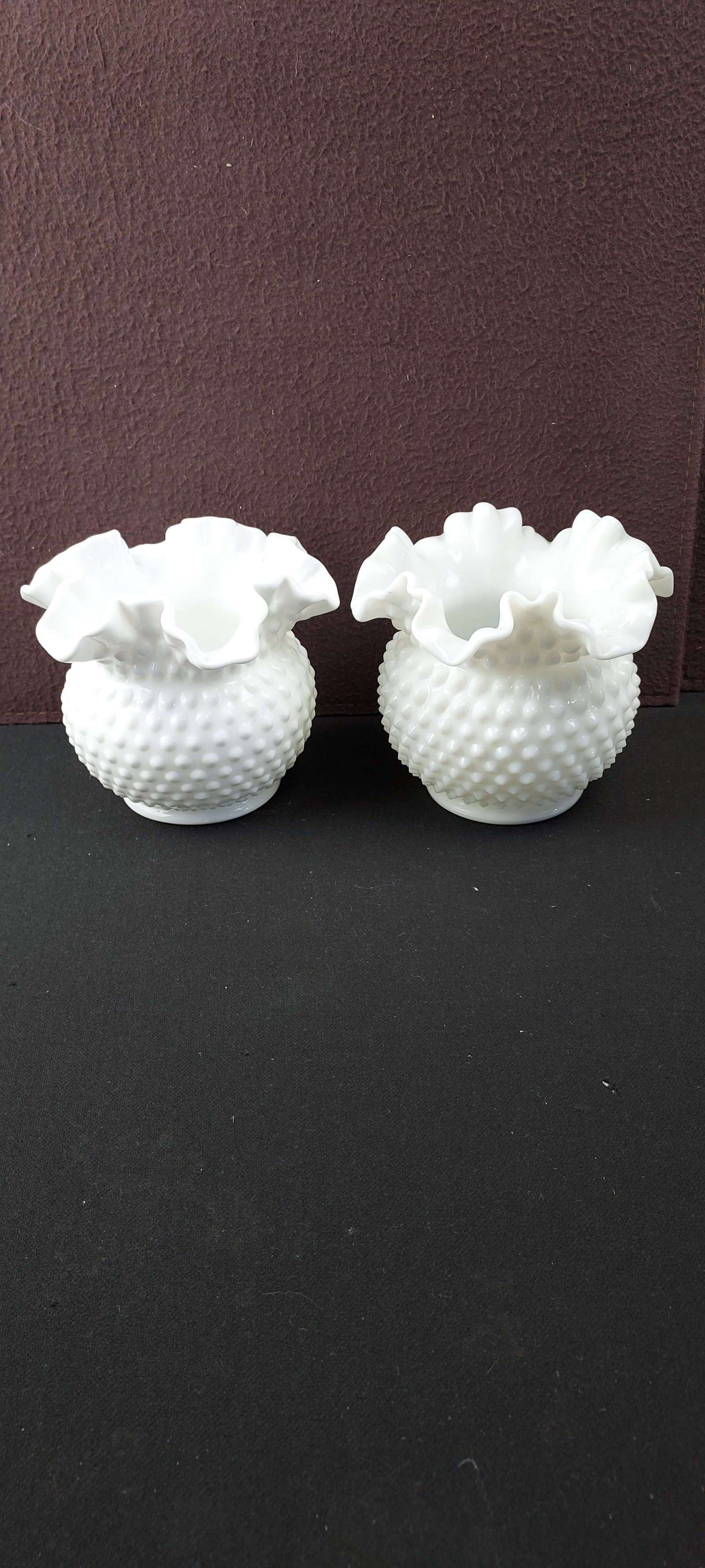 Pair of Fenton White Milk Glass Hobnail Ruffled Edge Rose Bowls: A pair of vintage Fenton Art Glass white milk glass hobnail rose bowls. Each piece features a classic rounded body adorned with a distinctive textured hobnail pattern, culminating in a wide, elegantly