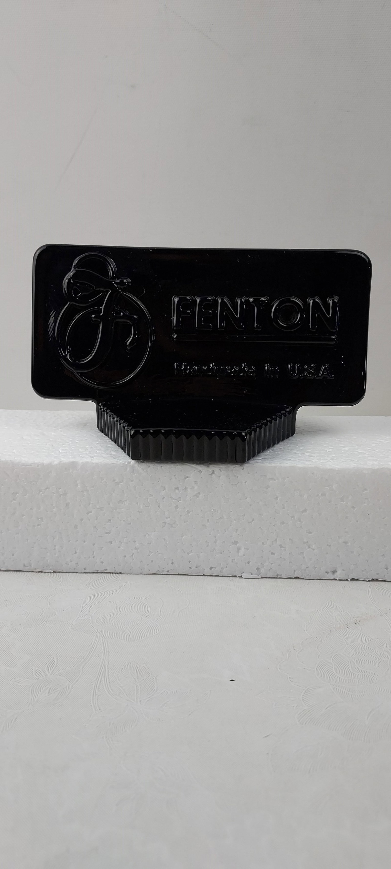 Fenton Black Ebony Glass Logo Dealer Display Sign: This is a Fenton Black Ebony molded glass logo display sign, often used by dealers. The front surface features the iconic "FENTON" brand name in raised lettering alongside a stylized 'F' logo, with "M