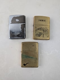 A Lot of Three Zippo Lighters including a 1996 Doral 'Welcome to Tobaccoville' Brass Lighter