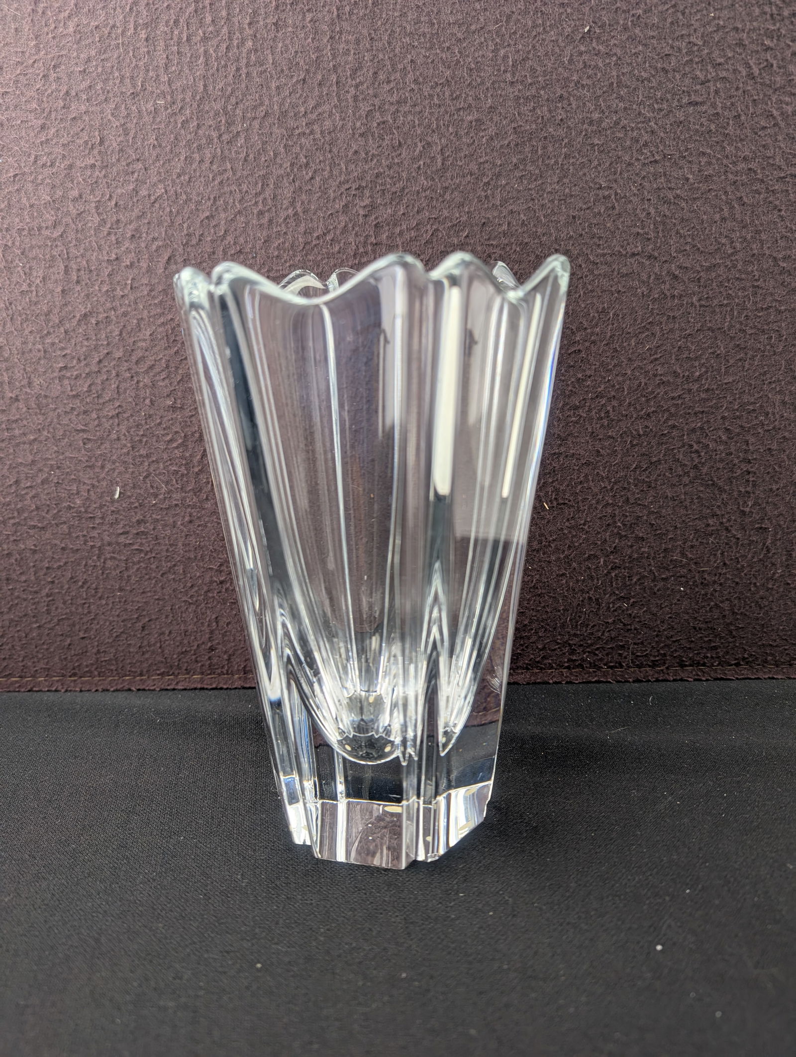 Clear crystal vase with vertical fluted panels and scalloped rim, heavy faceted base and bright: Clear crystal vase featuring tall vertical fluted panels that rise to a softly scalloped rim, set on a substantial faceted base. The vase has strong clarity and weight, producing attractive light refr