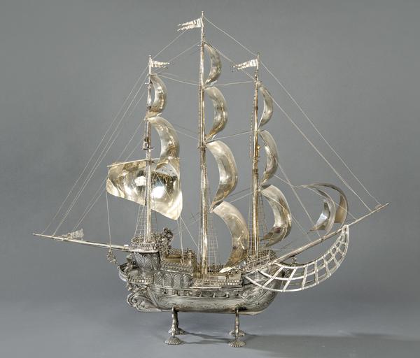 Large three-masted ship, made of Spanish silver.: Large three-masted ship, made of Spanish silver.With the sails in the wind and on deck characters and cannons. On four veined legs.Weight: 5,298 Kg.Size: 87 x 27 x 92 cms.