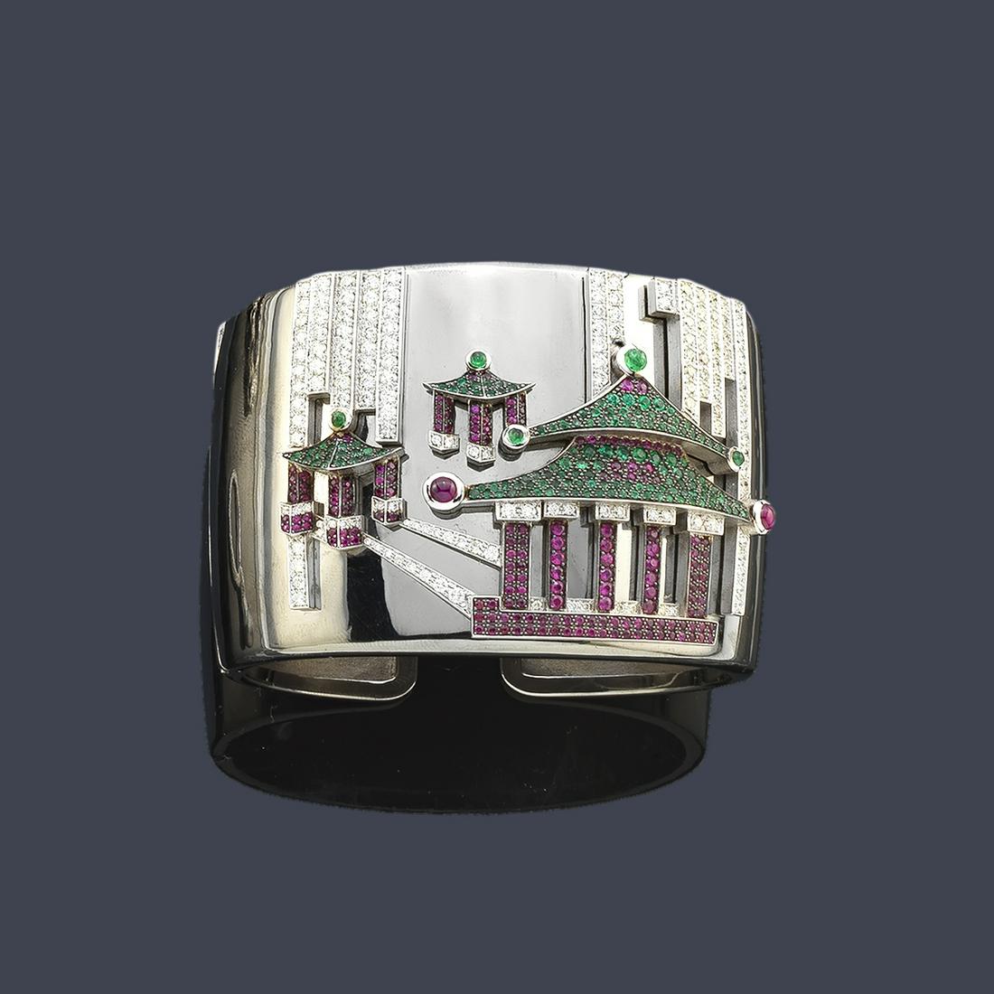 LUIS GIL Rigid bracelet from the 'Pagodas' collection: It presents a front design with three pagodas set with rubies and emeralds blued in black, enriched with bands of diamonds. In 18K gray gold with mirror polish.