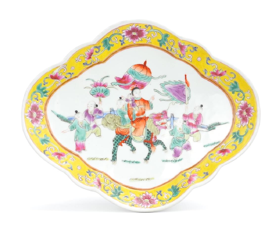 Chinese Famille Rose "Parade" Fruit Plate,19th C.: A wide diamond-shaped Chinese Famille Rose dish with a raised foot and softly scalloped edges. The central image shows a woman and two children on the back of a dragon-horse while onlookers watch and