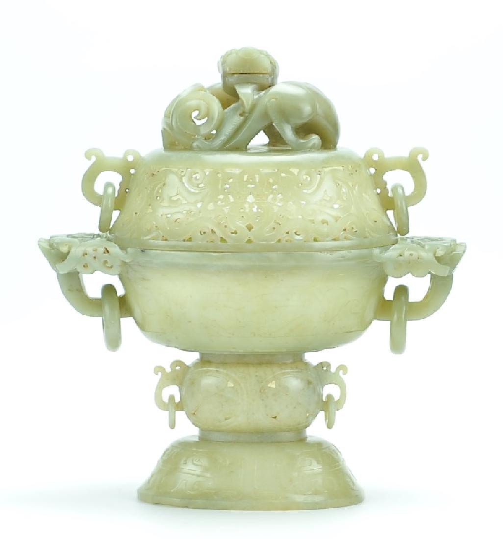 Chinese Jade Censer: A warm translucent brown-green jade incense burner/ censer from China with a three tier base and two tier lid in a tapering oval shape. The lid has a carved openwork mesh of Taotie and beaked serpents