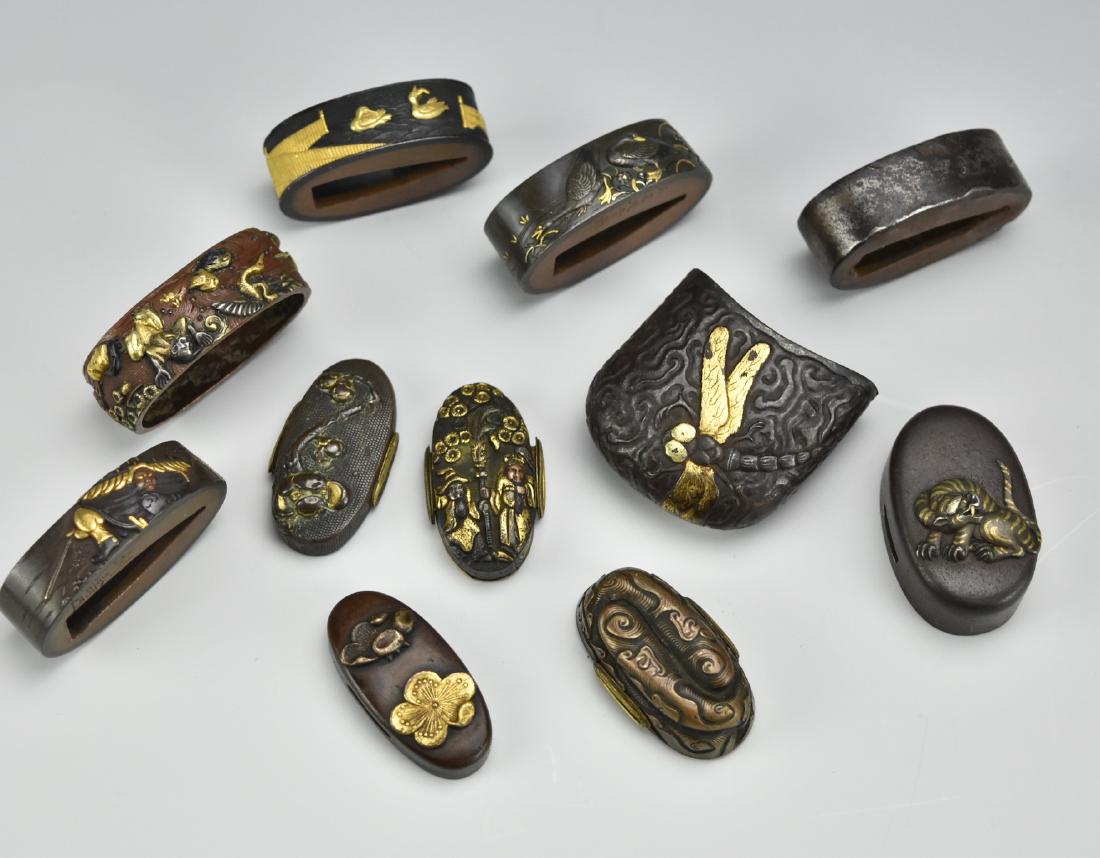 Group of 11 Japanese Sword / Katana Accessories: A group of Eleven Japanese sword accessories: - 1 pommel/ kashira with gold embossed dragonfly & maple leaf - 5 habaki/ blade-collars: - Gold embossed: geese within a fence - Gold embossed: geese fora