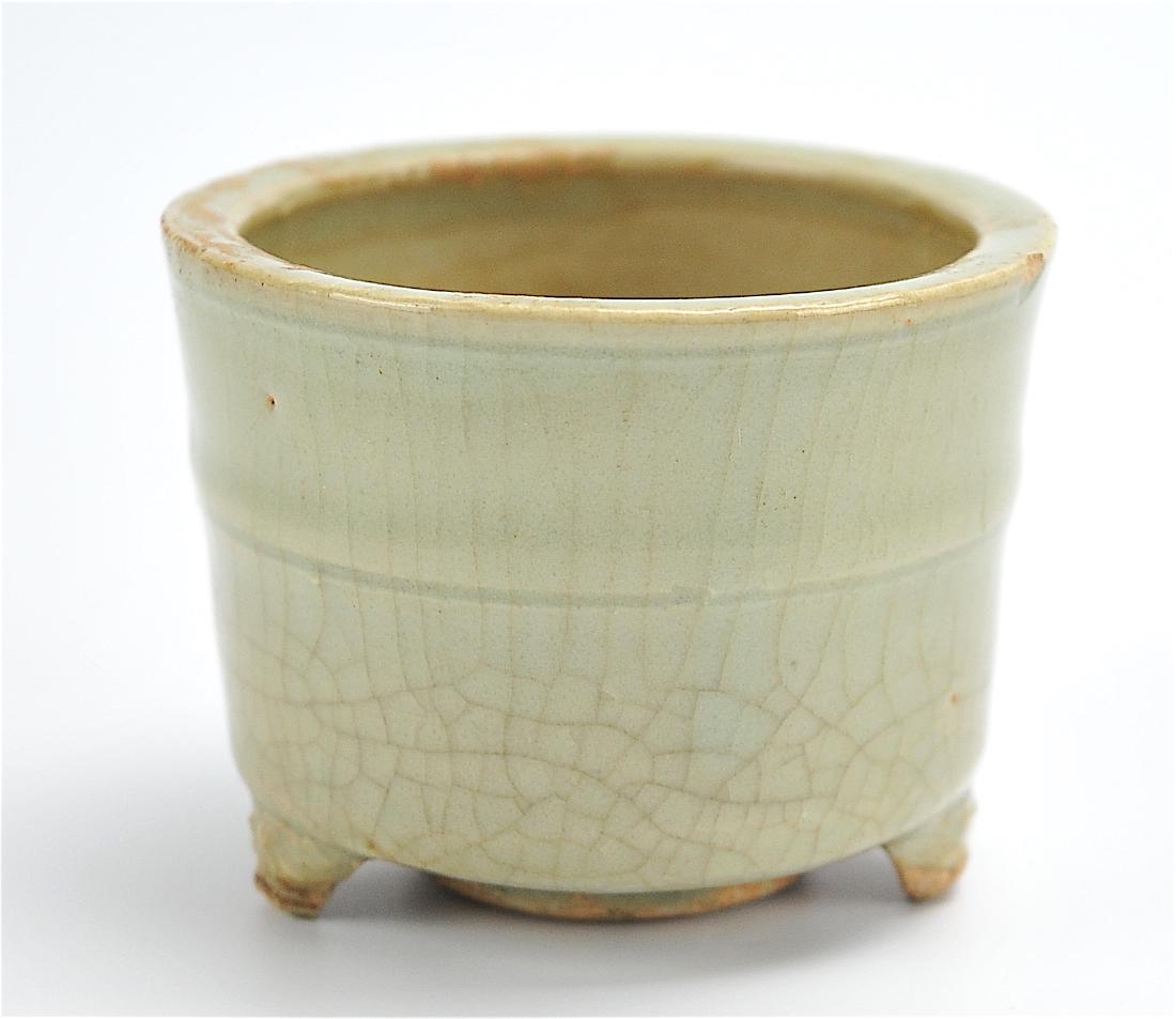 A Longquan Ware Tripod Censer, Yuan D.: A Yuan Dynasty Longquan ware tripod censer with sculpted feet & a raised band along the outer wall. provenance: collection from a private Maryland collector H. 2 3/8in. (6cm), D. 3 1/8in.(8cm) Conditi
