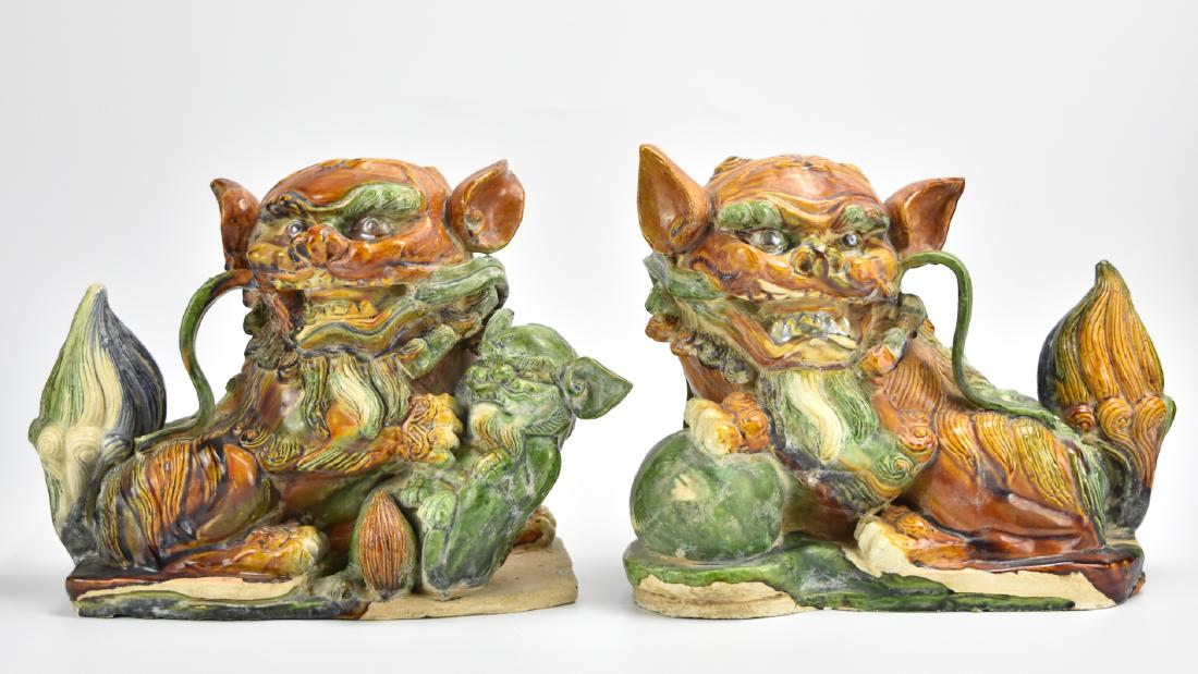Pair of Sancai Glazed Porcelain Foo-Dogs: A pair of large, Chinese, sancai glazed, porcelain Foo-dogs/ Guardian-lions in typical pose, with unusual prominent whiskers, bushy tails, and pearlescent pigmented paint in the eyes and mouths. H: 10