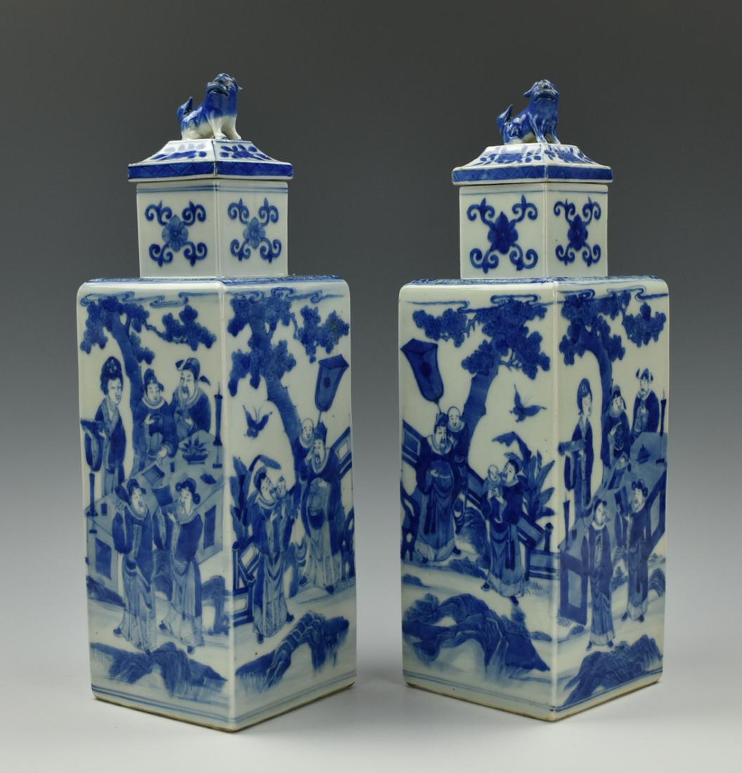Pair of Chinese Blue & White Square Vase, 19th C.: A pair of matching, Chinese, blue and white porcelain vase with square bases, a straight, squared neck, and a squared dome lid with a god beast on the top. Both of the vase bodies are painted with a s