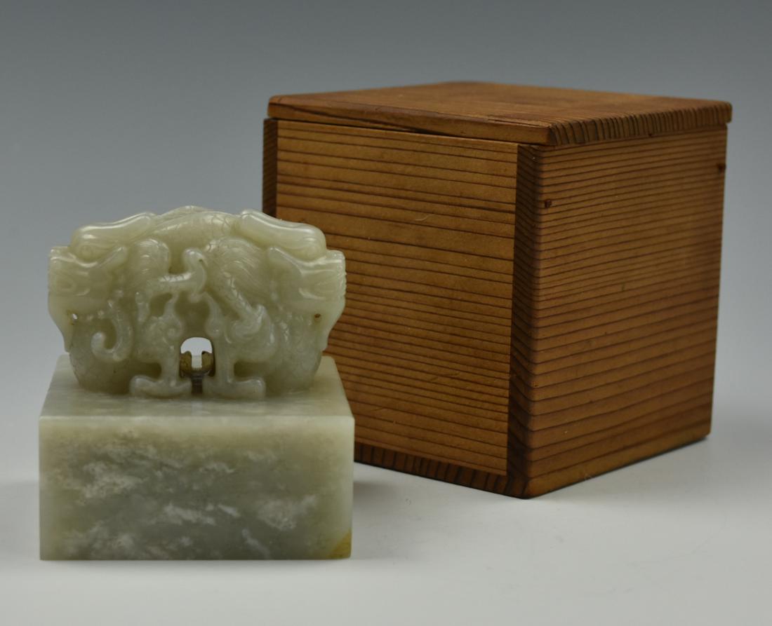 A Hetian/ Hotian Jade "Double Headed Dragon" Seal: A large Hotan/ Hetian/ "mutton fat" colored seal carved from a single piece of jade, the square base inscribed along all four sides with Chinese characters, the surface/ bottom of the seal with 5 larg
