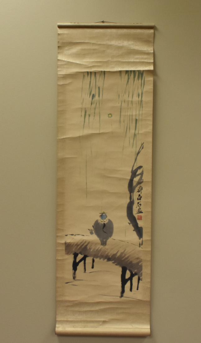 Chinese Scroll Painting: "Man w/ Kite": A Chinese water media scroll painting which appears to show a bearded hatted gentleman flying a kite in a copse of bamboo on the back of an ox, with calligraphy and seal on the lower right, wooden bar
