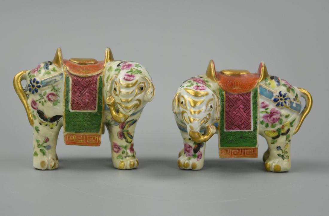 Pair of Chinese Cantonese Elephant Statues, 19th C: A pair of Chinese, porcelain, Cantonese elephant, the exterior deftly enameled in varying tones of rose-pink, purples, yellow and greens with intertwining layers of flowering branches of lush peony, a