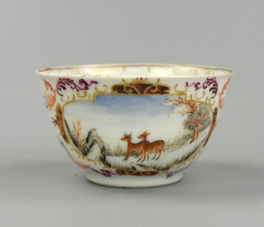 A Chinese Export Cantonese Glazed Cup, 18th C.: A Chinese, porcelain, export Cantonese cup, the exterior painted with two gilt cartouches enclosing a rocky landscape with two deer and trees, decorated with a stylized spray in iron-red and purple to