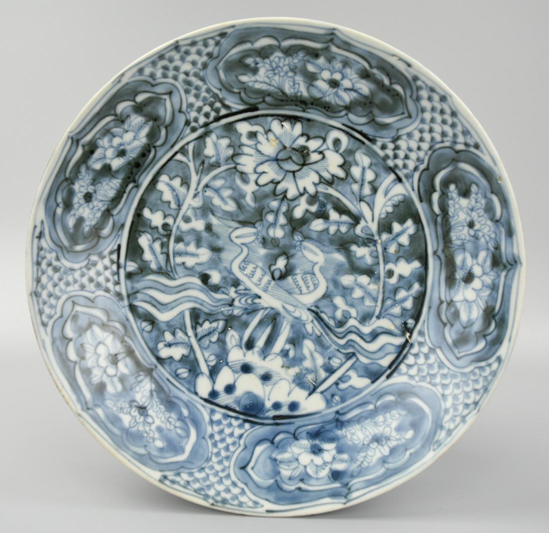 Large Chinese Blue & White Floral Charger, Ming D.: A large, Ming dynasty, blue & bone white, Chinese porcelain plate, the face with a pair of phoenixes between tall plants beneath a large flower, with five shaped panels of flowers within a diapered ba