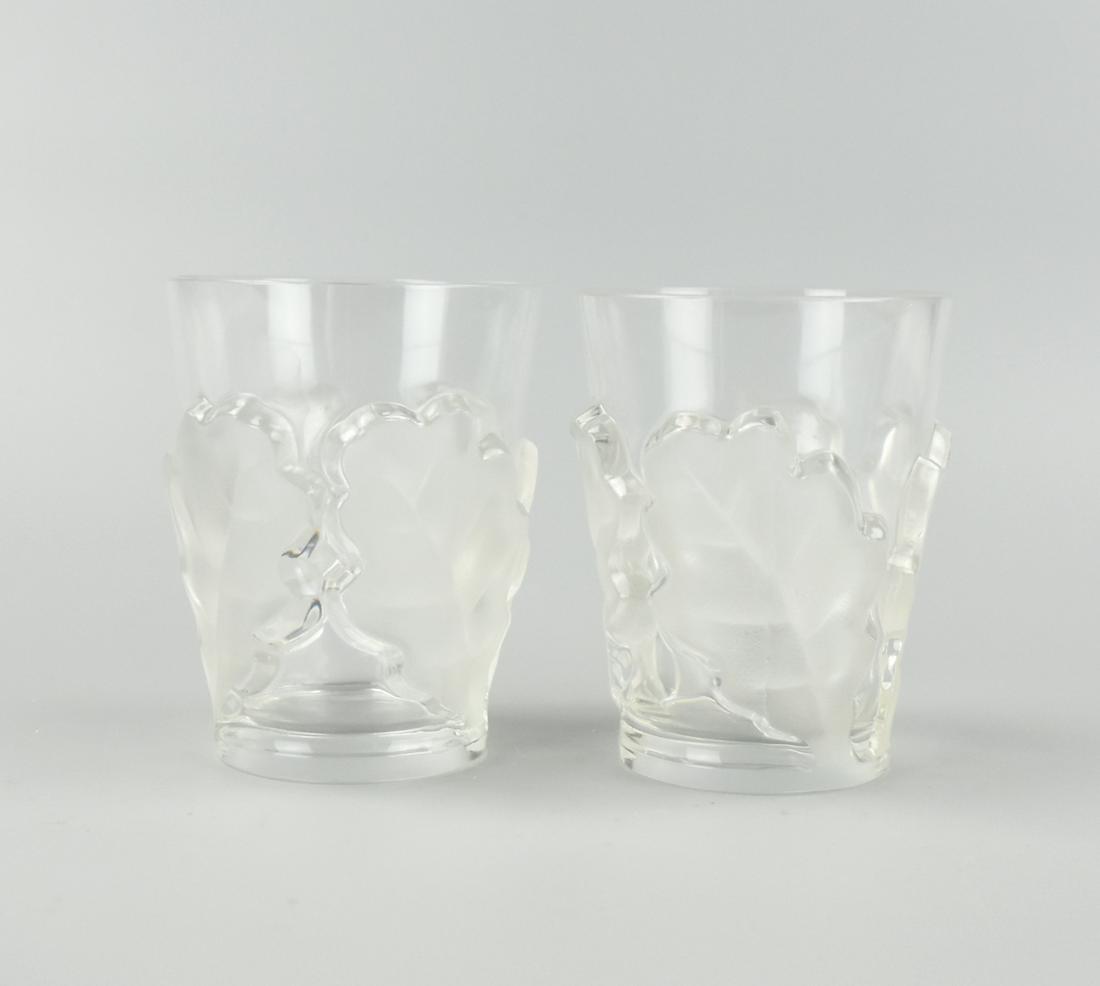 A Pair of Vintage 70's Lalique Glass Tumblers: Vintage 70's Lalique France "Femmes Antiques" 2 Whiskey Tumblers. H: 4 3/4 in. (12cm.) Condition: Very fine micro scratches at the bottom, not easily seen by eye. The tumbler is in excellent condition