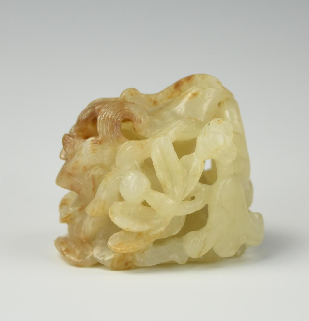Chinese Yuan Style Carved Jade Ornament: A Chinese, Yuan style, white traces of brown, finely carved in relief with a bird among leaves with blossoming flowers and buds H: 1 1/8" (4 cm) D: 1 5/16" (3.4cm) Condition: In excellent condition wi