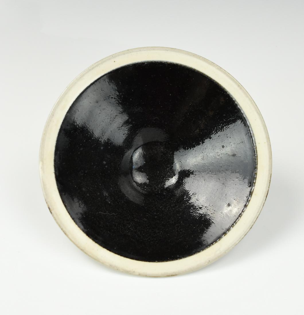 Chinese Cizhou Ware Black Glazed Bowl w/ White Rim: the conical bowl is covered in a thick, glossy black glaze ending inregularly aboved exposed buffed pottery foot, and the rim is covered with a band of creamy white slip under a clear glaze H: 1 5/8"(