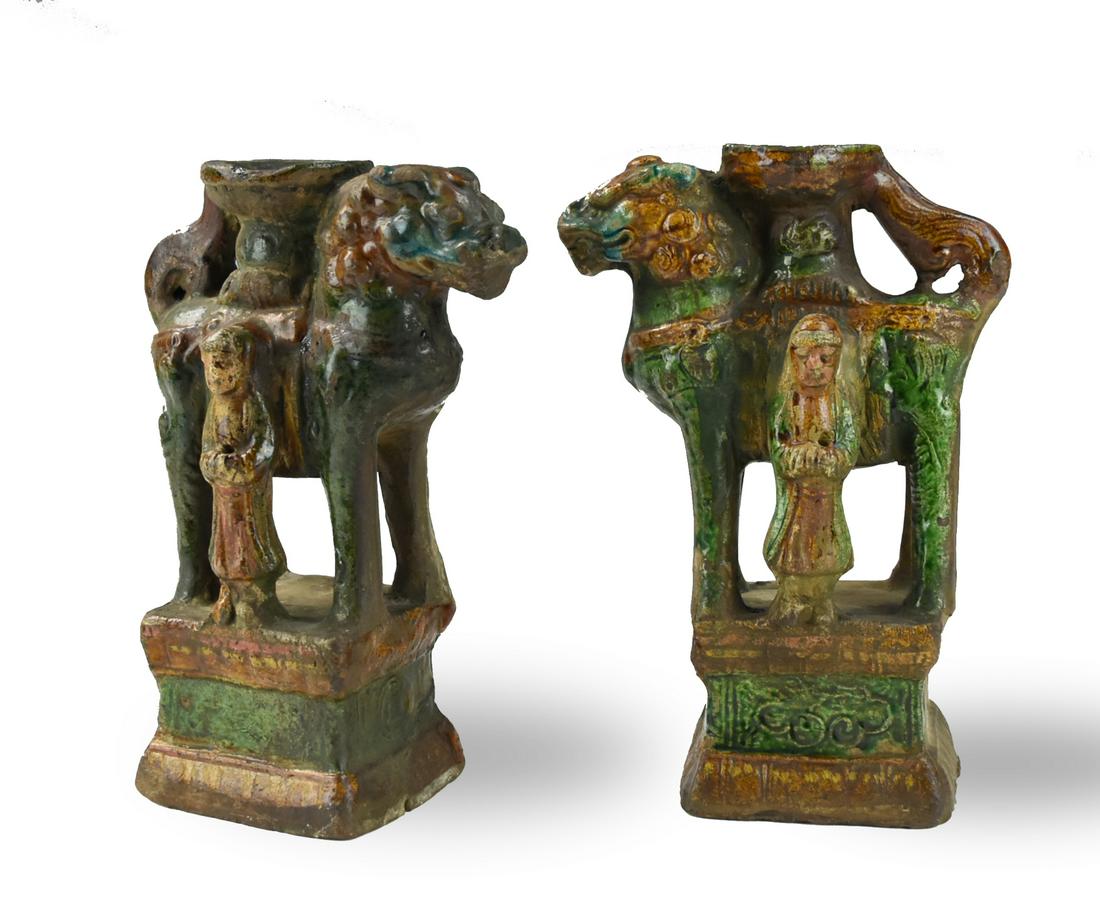 Pair of Chinese Sancai Glaze Candlestick, Ming D.: Chinese ,Ming Dynasty, each mythical beast modeled applied with green, mottled brown, and ocher glazes with a small human figure on the side, both standing on a suqared base H: 9.2"(23.3cm) D: 6.5"(16