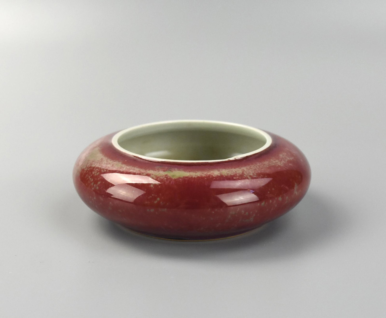 Chinese Peach-Bloom Glaze Washer: Chinese ,washer features a thick peach bloom red flambe glaze. Itâ€™s foot is circular, stout and glazed. The body of the washer is stout and top heavy with the rim sharply curling over the base 